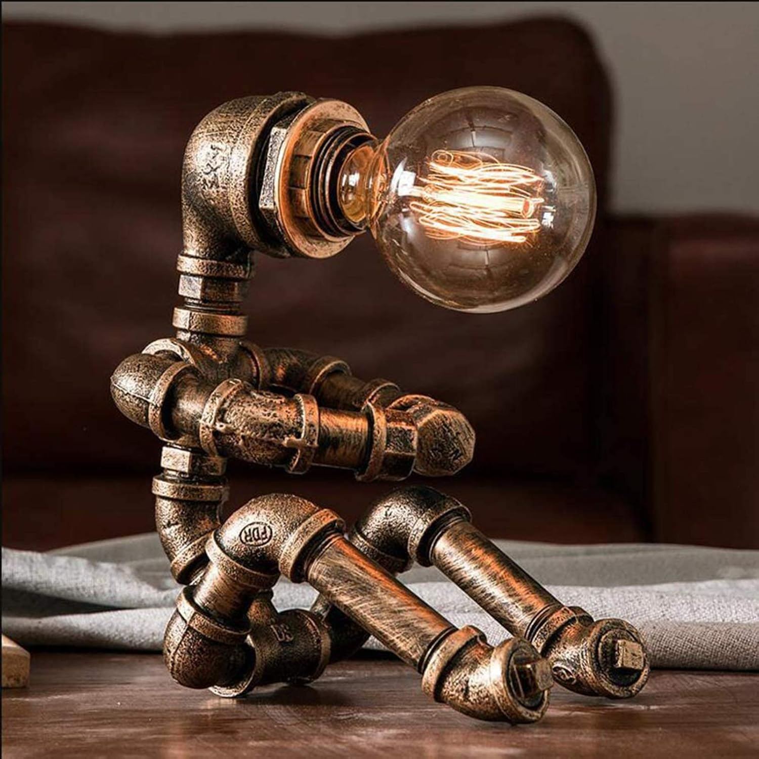 Metall-Steampunk-Lampe in sitzender menschlicher Form mit Glühbirne als Kopf.