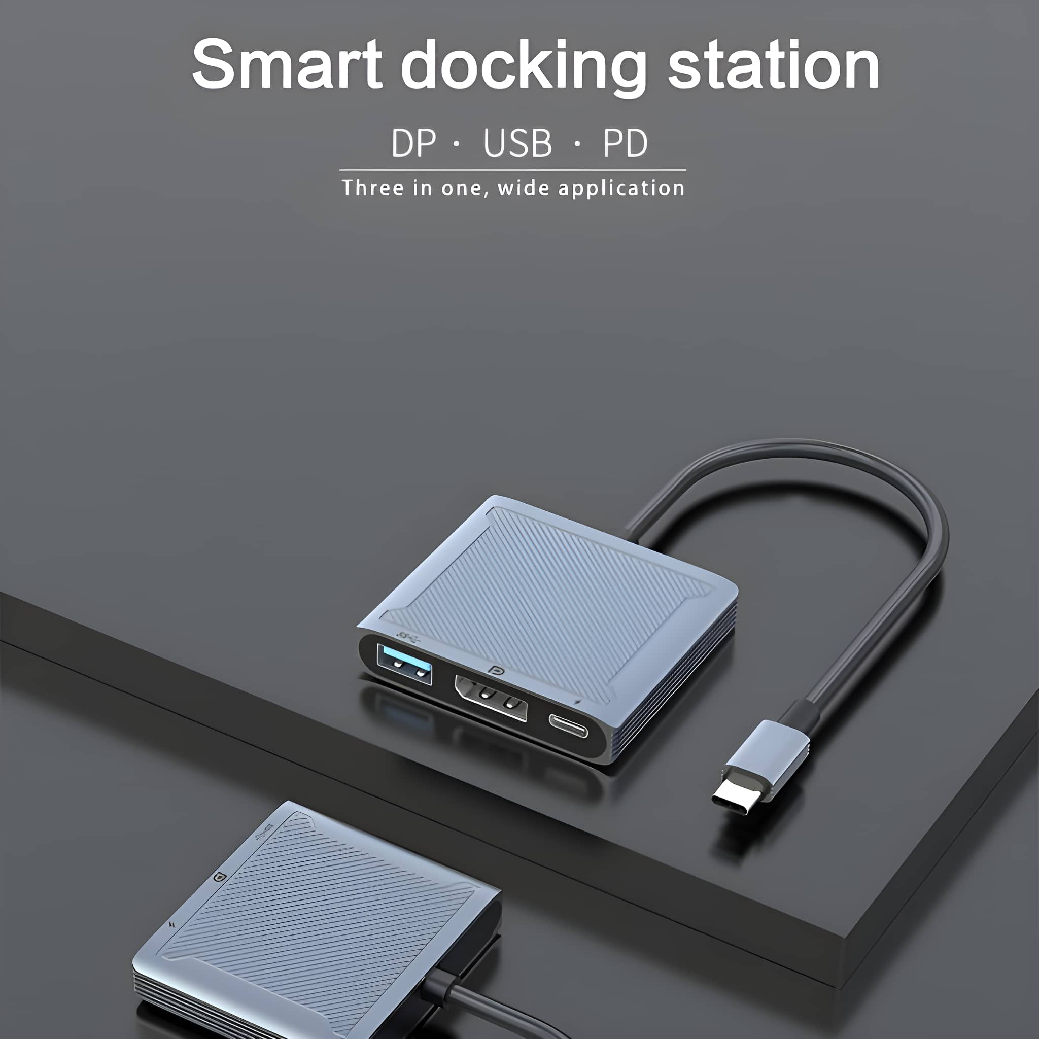 Eine graue Dockingstation mit mehreren Anschlüssen und einem Verbindungskabel, auf dunkler Oberfläche.