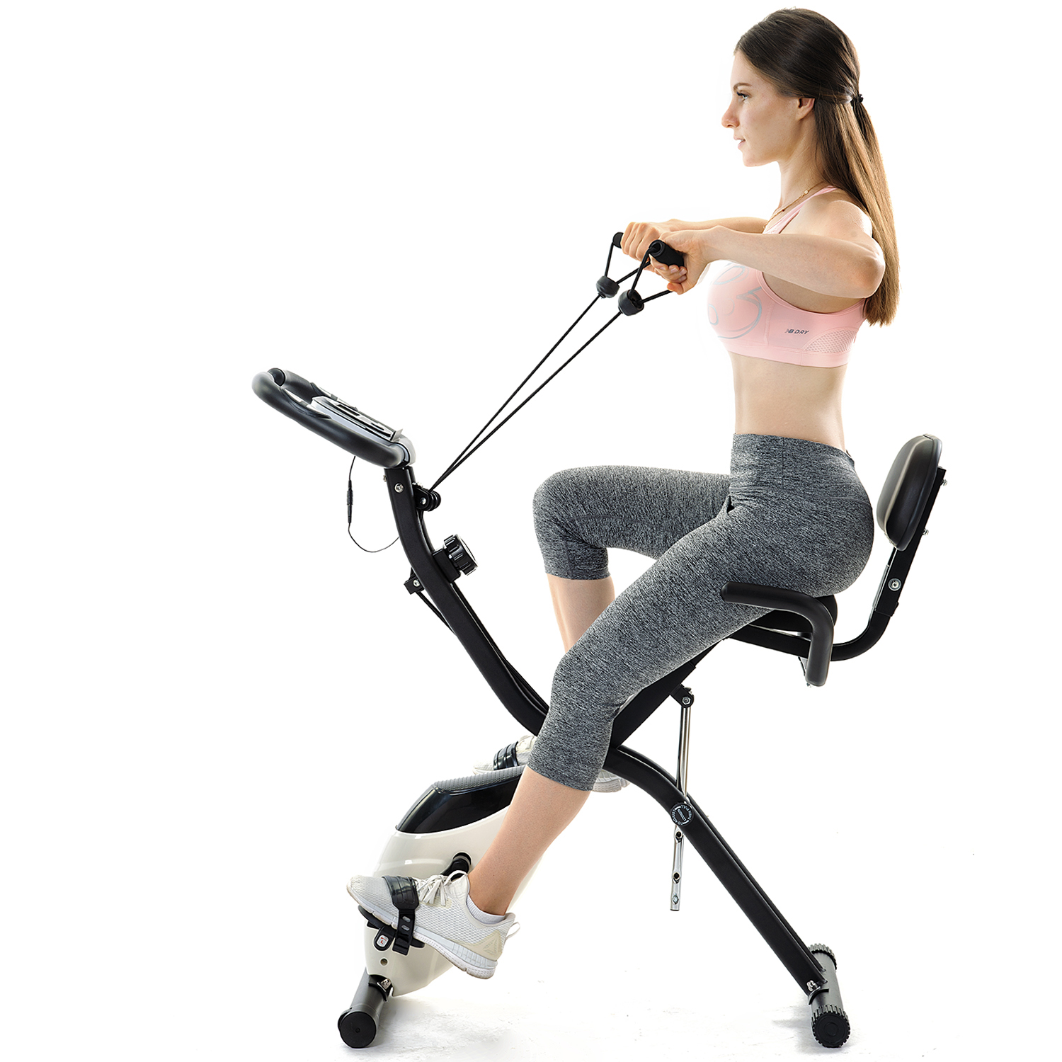Frau auf dem Heimtrainer, zieht Widerstandsbänder. Weißer Hintergrund.