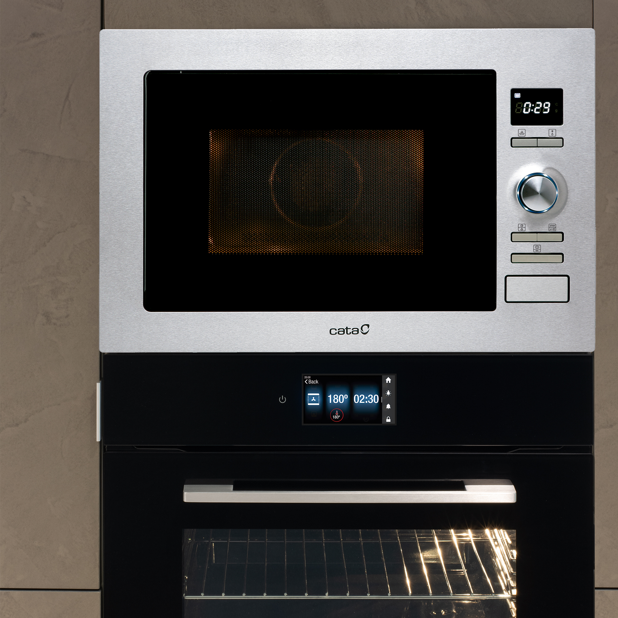 Horno microondas plateado encima de un horno negro, ambos con la marca 'cata'.
