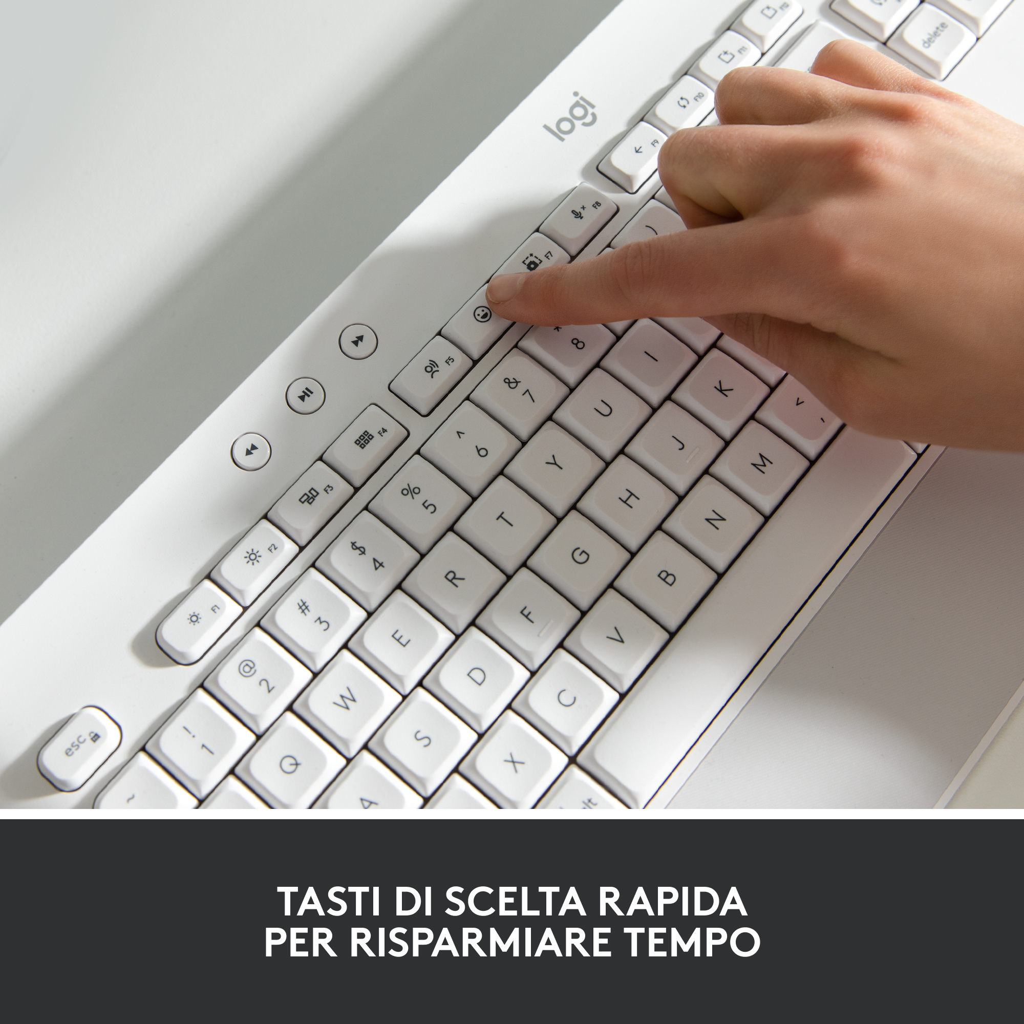 Eine Hand drückt eine Taste auf einer weißen Logitech-Tastatur mit dem Text 'TASTI DI SCELTA RAPIDA'.