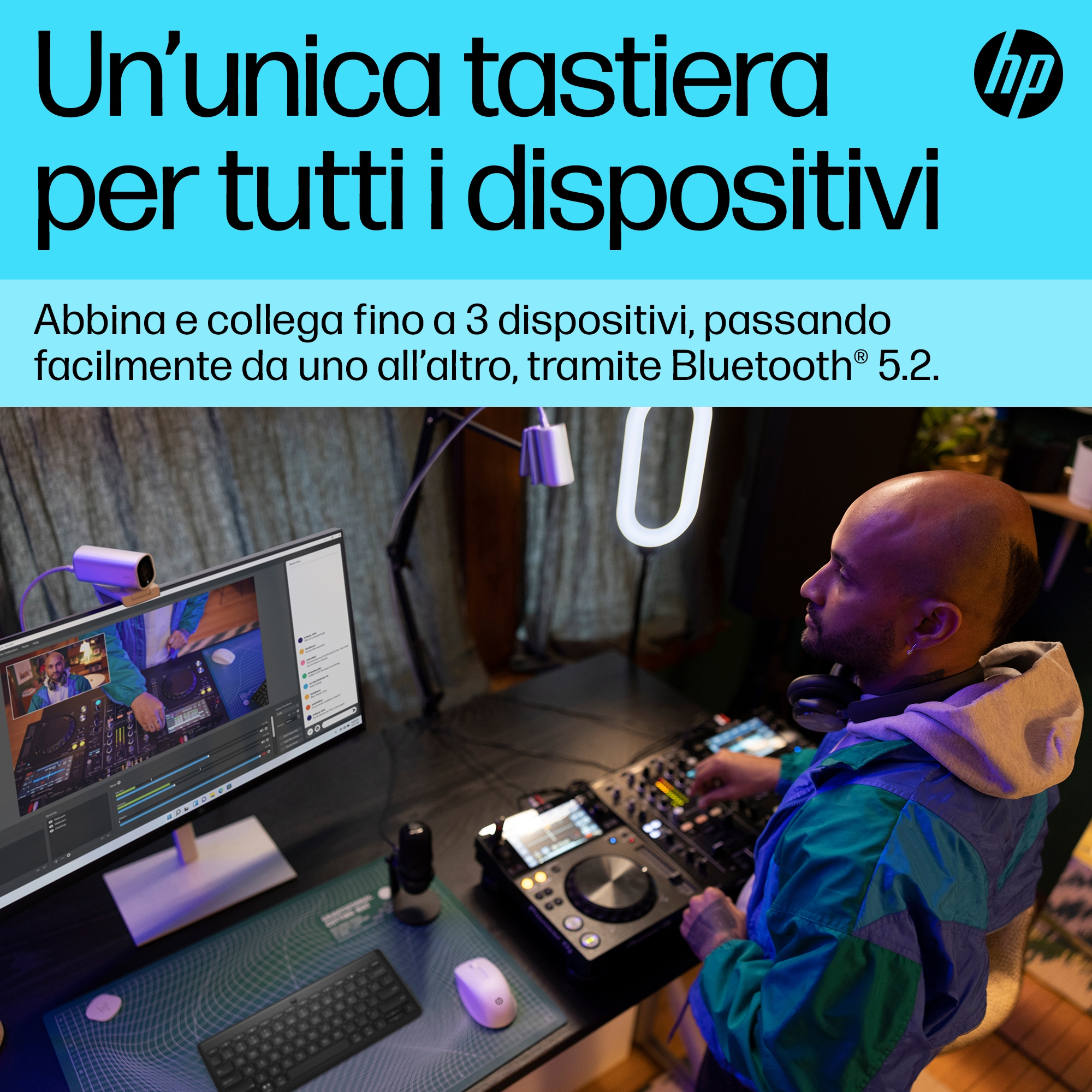 Un uomo usa un mixer e una tastiera. Un monitor mostra un feed video.