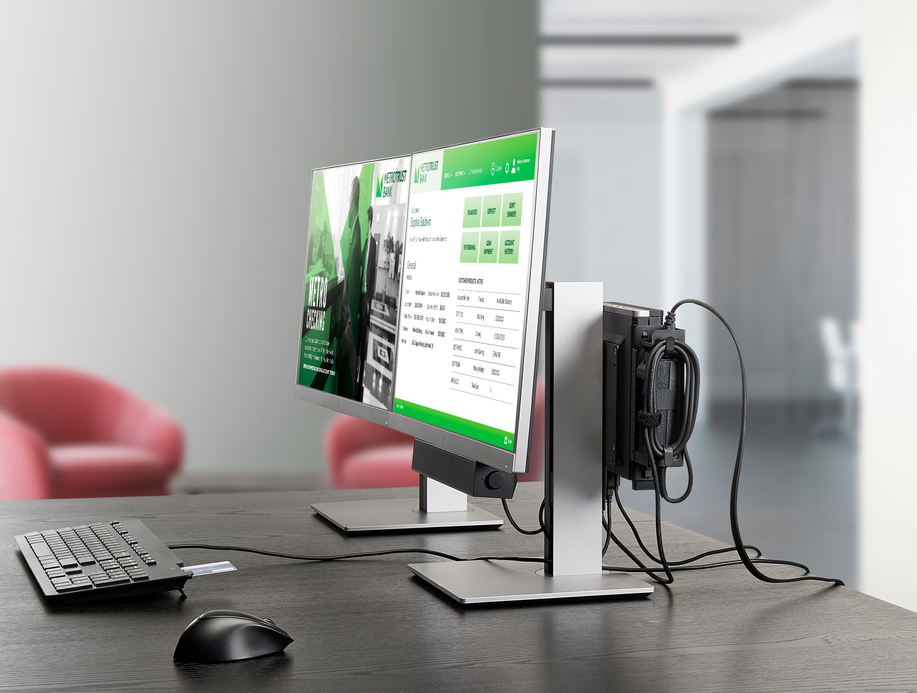 Two computer monitors with cables, keyboard, and mouse on a desk in an office setting.