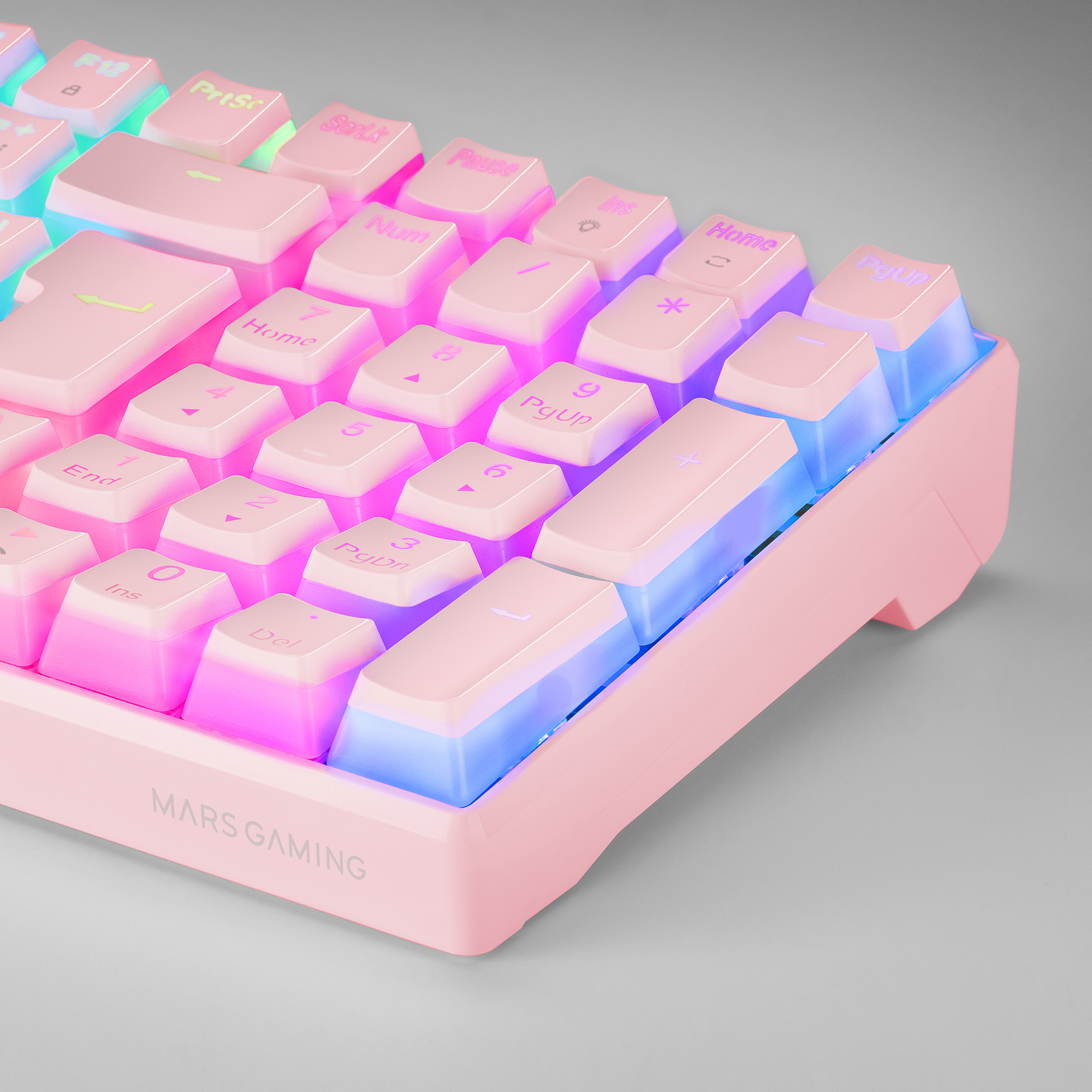 Primer plano de un teclado gaming rosa con teclas iluminadas en rosa y azul.