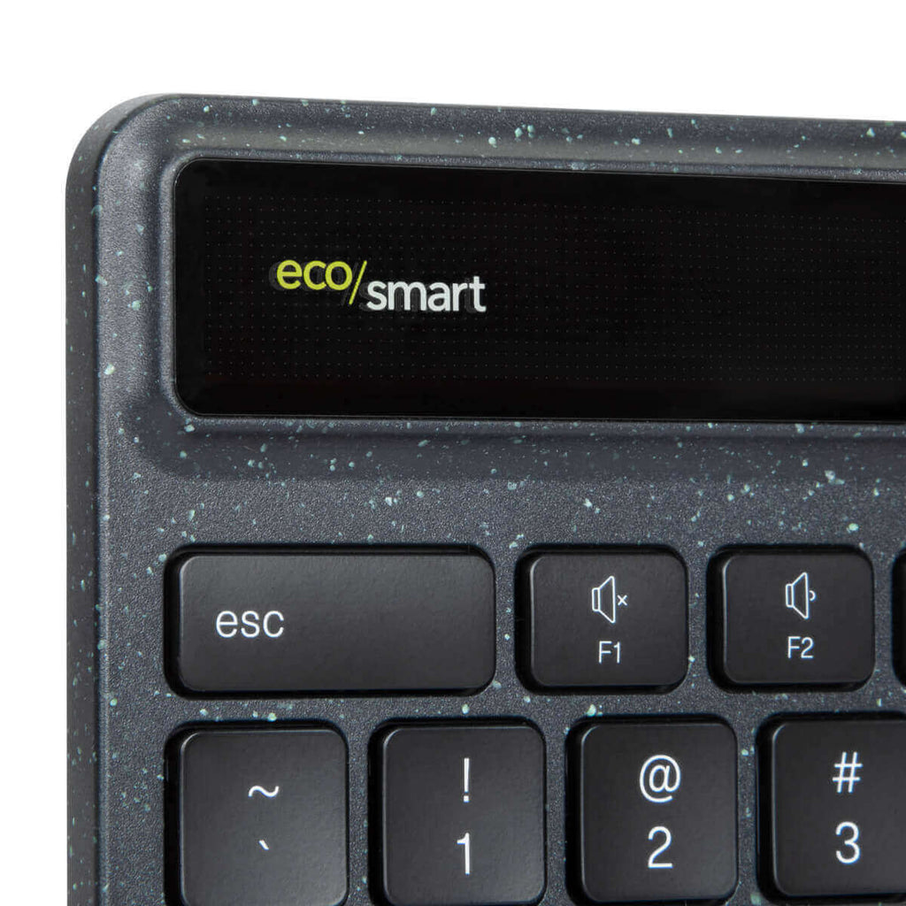 Primer plano de un teclado con teclas negras y superficie gris moteada.