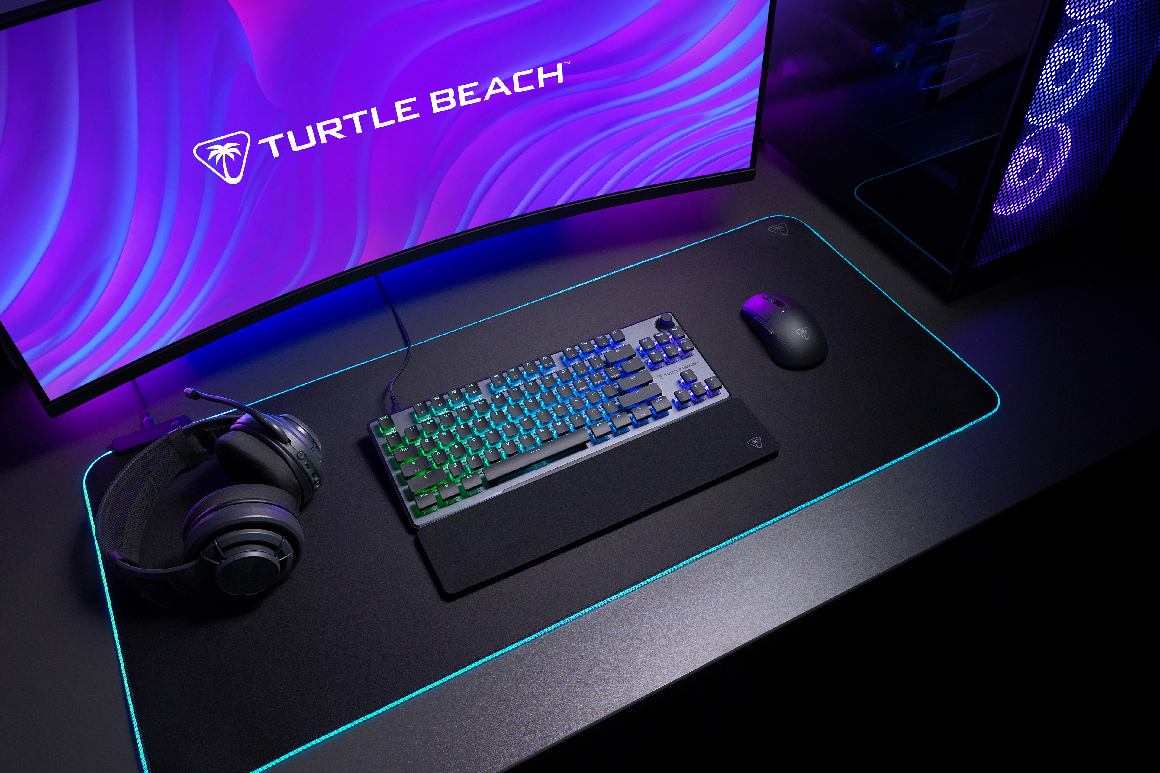 Gaming-Setup mit Tastatur, Kopfhörern, Maus und gebogenem Monitor.