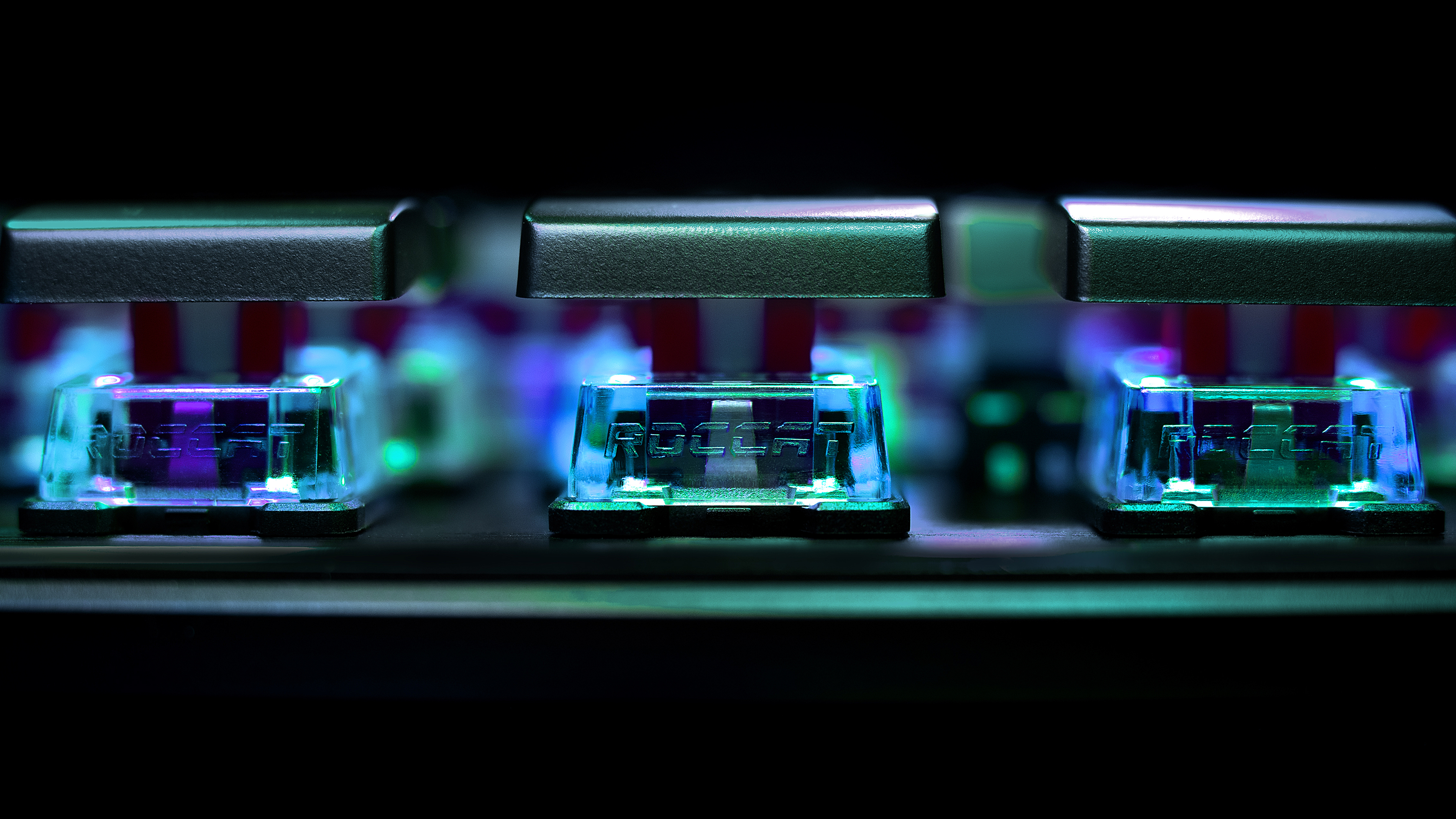 Zbliżenie na przełączniki klawiatury z podświetlanymi klawiszami. Niebieskie i fioletowe światła.