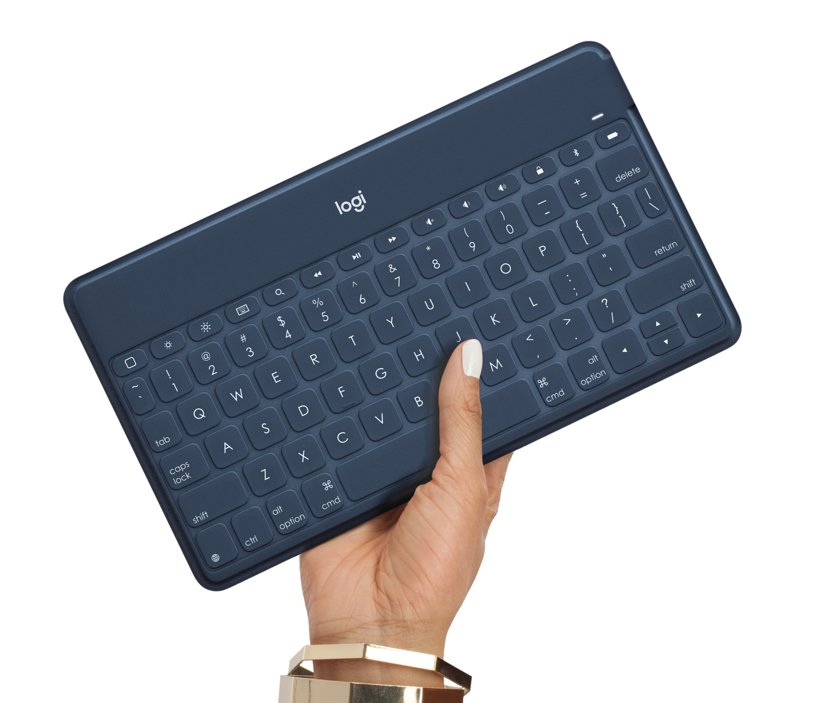 Una mano che tiene una tastiera wireless blu scuro. La tastiera è una Logitech.