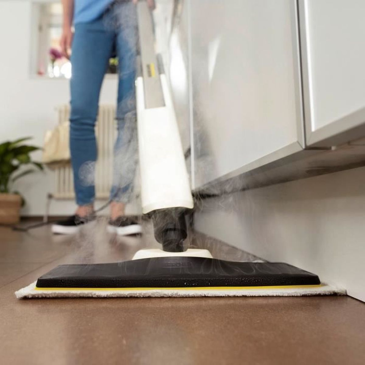 Osoba czyszcząca podłogę za pomocą parownicy.