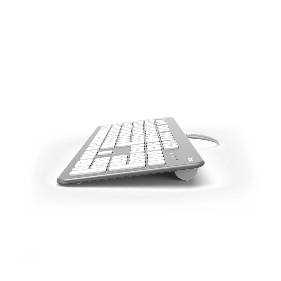 Silberne Tastatur mit weißen Tasten auf weißer Oberfläche. Sie hat eine abgerundete Unterkante.