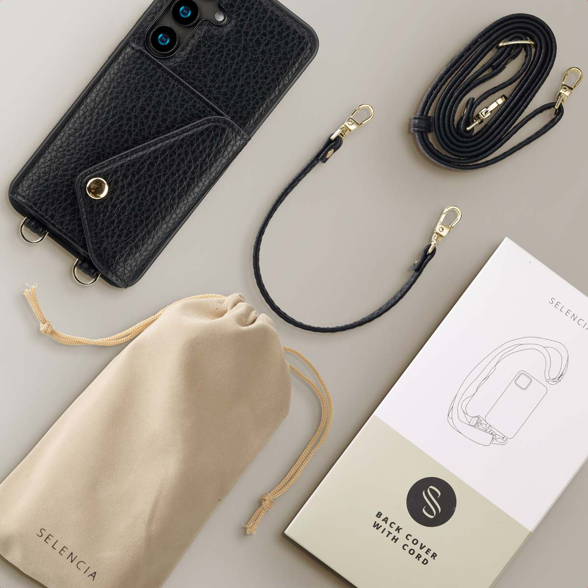 Zwarte leren telefoonhoes met een bandje. Inbegrepen, een beige zakje en een doos met een telefoonillustratie.