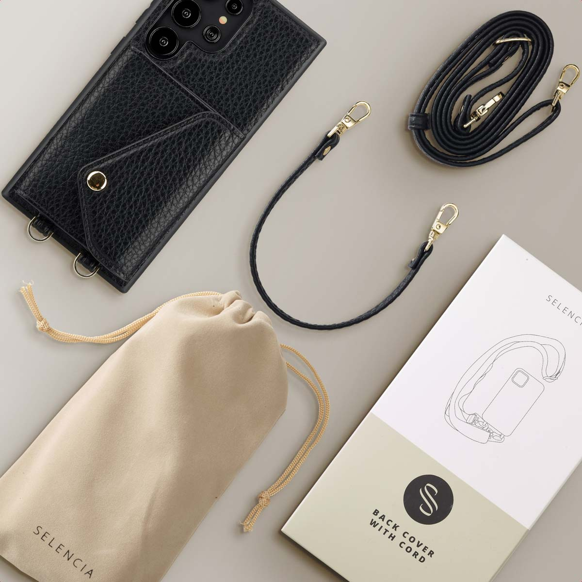 Étui de téléphone noir avec poche, lanière et pochette. Vue de dessus. Boîte blanche avec dessin de cordon à droite.