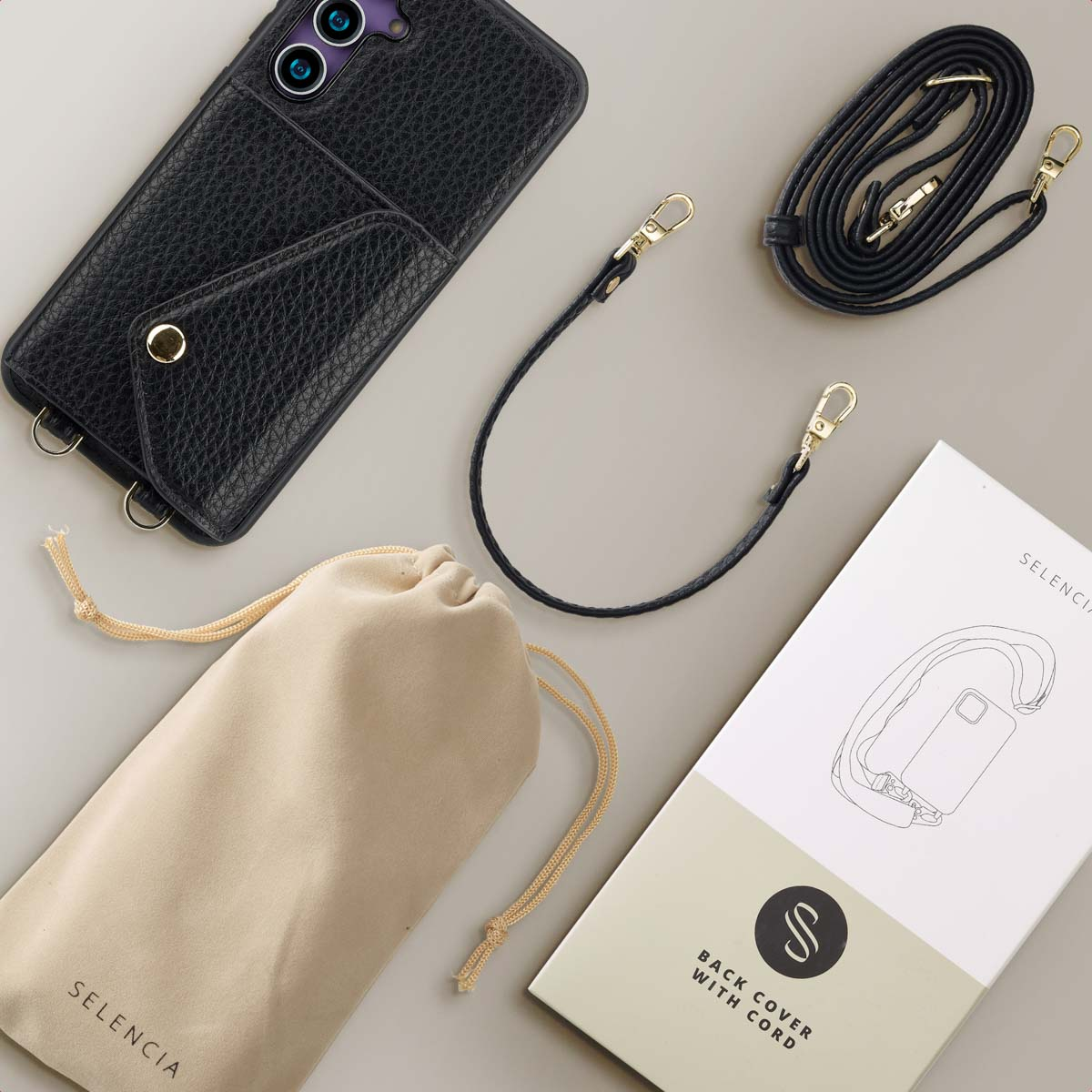 Zwarte telefoonhoes met riem, etui en merk op de verpakking. Grijze achtergrond.