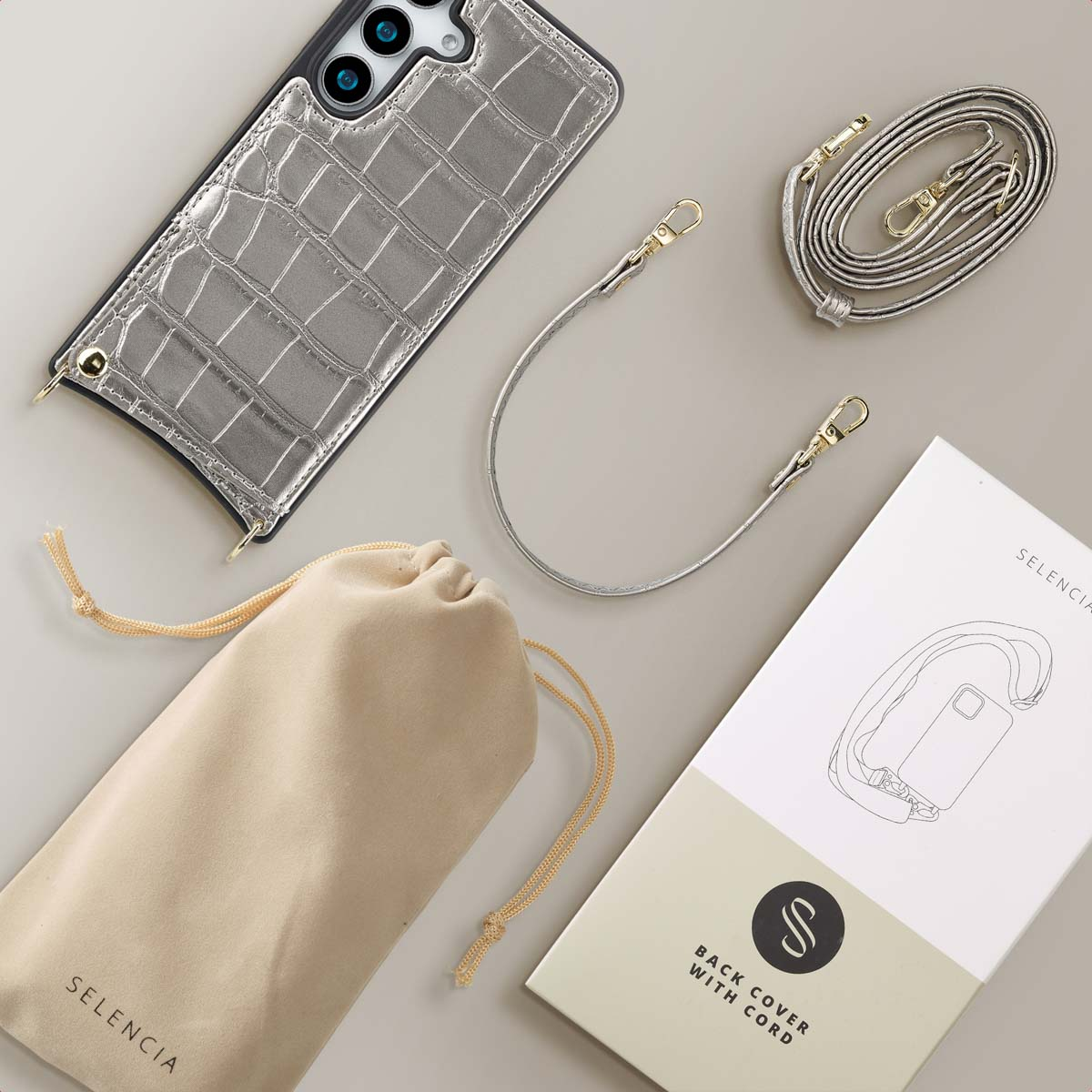 Zilveren telefoonhoesje, riem, zakje en doos.