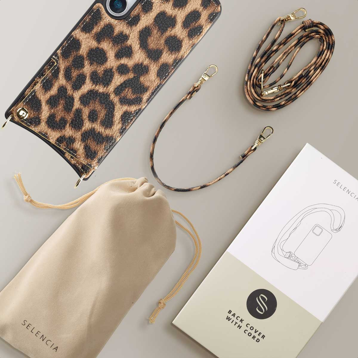 Custodia per telefono con stampa leopardata, cinturino e accessori disposti con una scatola Selencia.