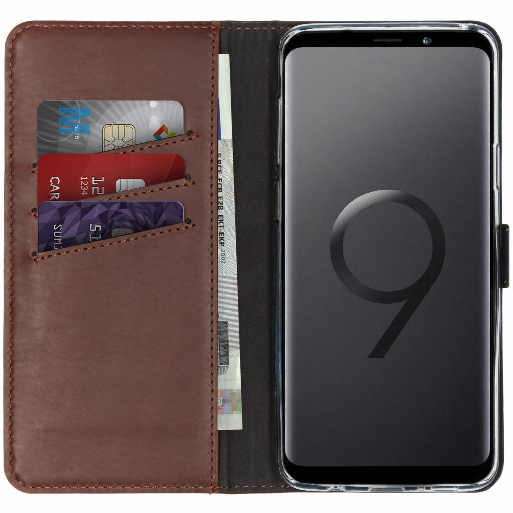 Coque de téléphone marron avec cartes et argent à l'intérieur. Le téléphone est à droite.