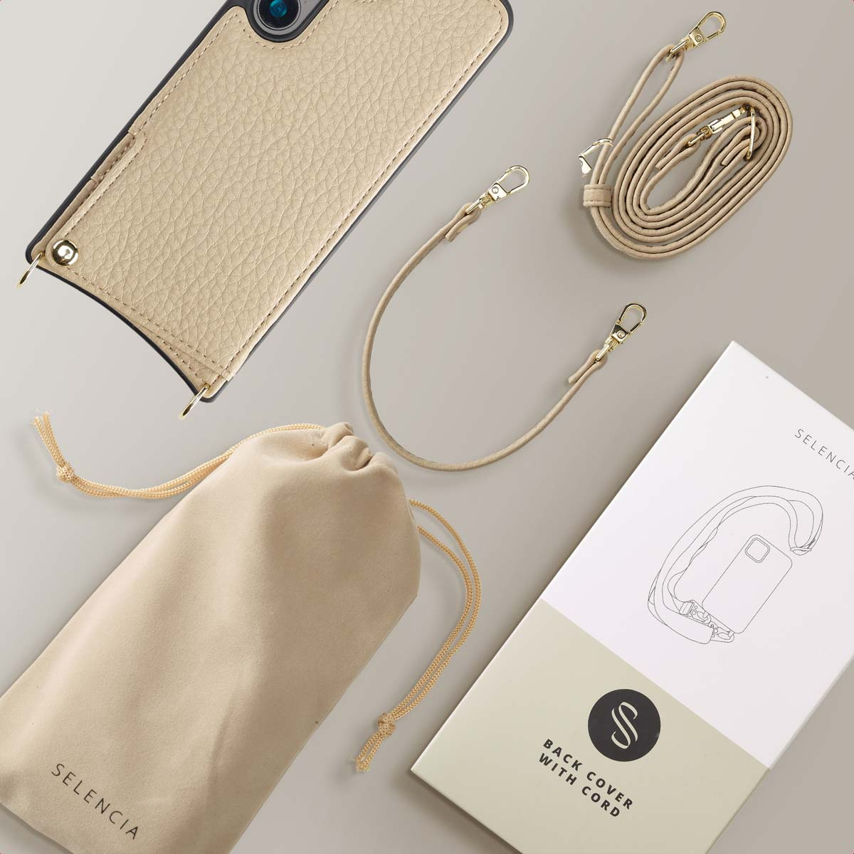 Custodia beige per telefono con cinturino, tasca e scatola su superficie grigia.