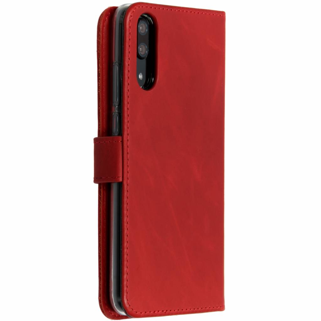 Étui de téléphone rouge ouvert, révélant le téléphone et la doublure intérieure, avec fermoir magnétique.