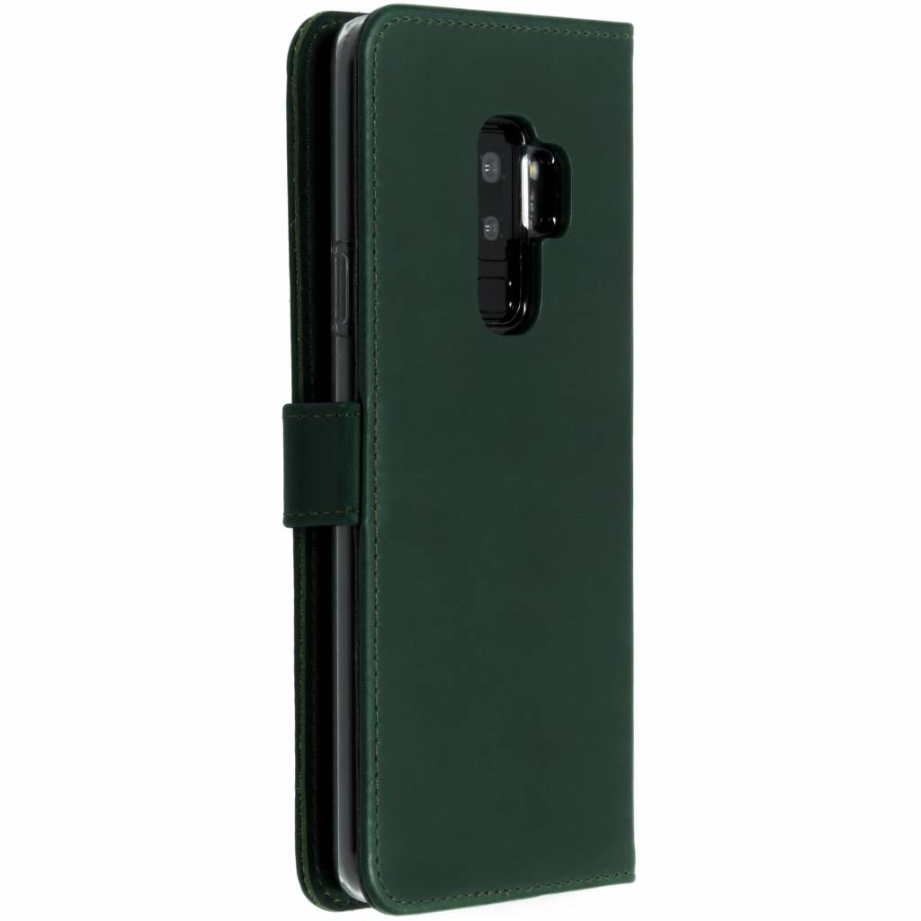 Coque de téléphone verte fermée avec un bouton et un téléphone à l'intérieur, vue latérale.