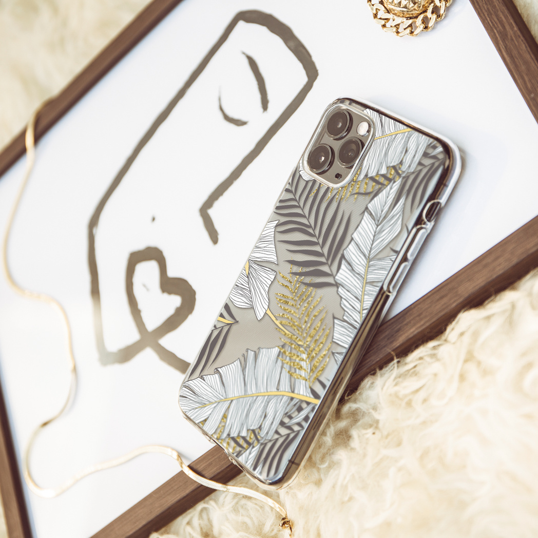 Telefoonhoesje met een bladerontwerp. Een schilderij van een gezicht op de achtergrond met een gouden ketting.
