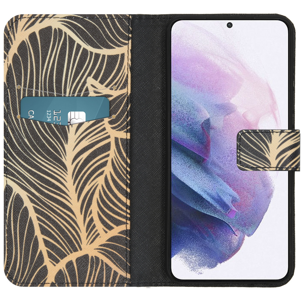 Une coque de téléphone avec un motif de feuilles dorées sur fond noir. Une carte de crédit est visible.