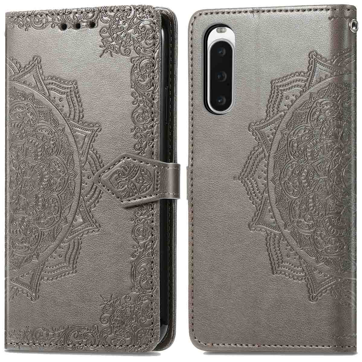 Grijze telefoonhoes open, met een telefoon met camera. De hoes heeft een mandala-ontwerp. Een sluiting houdt het dicht.