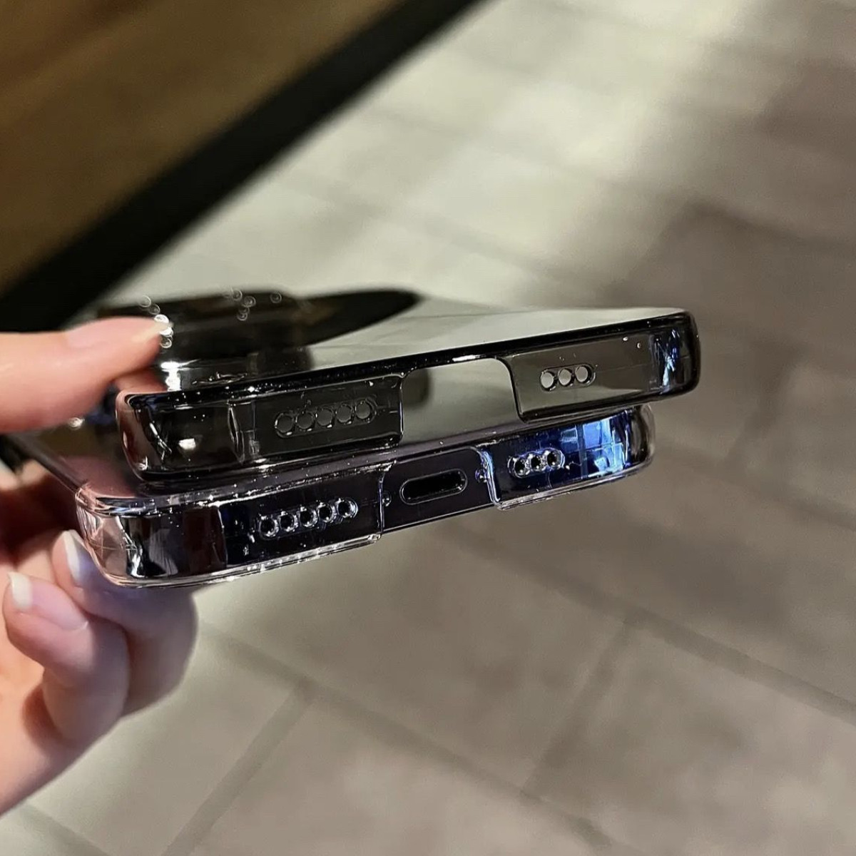 Due custodie per telefono nere, che mostrano la parte inferiore, da vicino, in una mano.