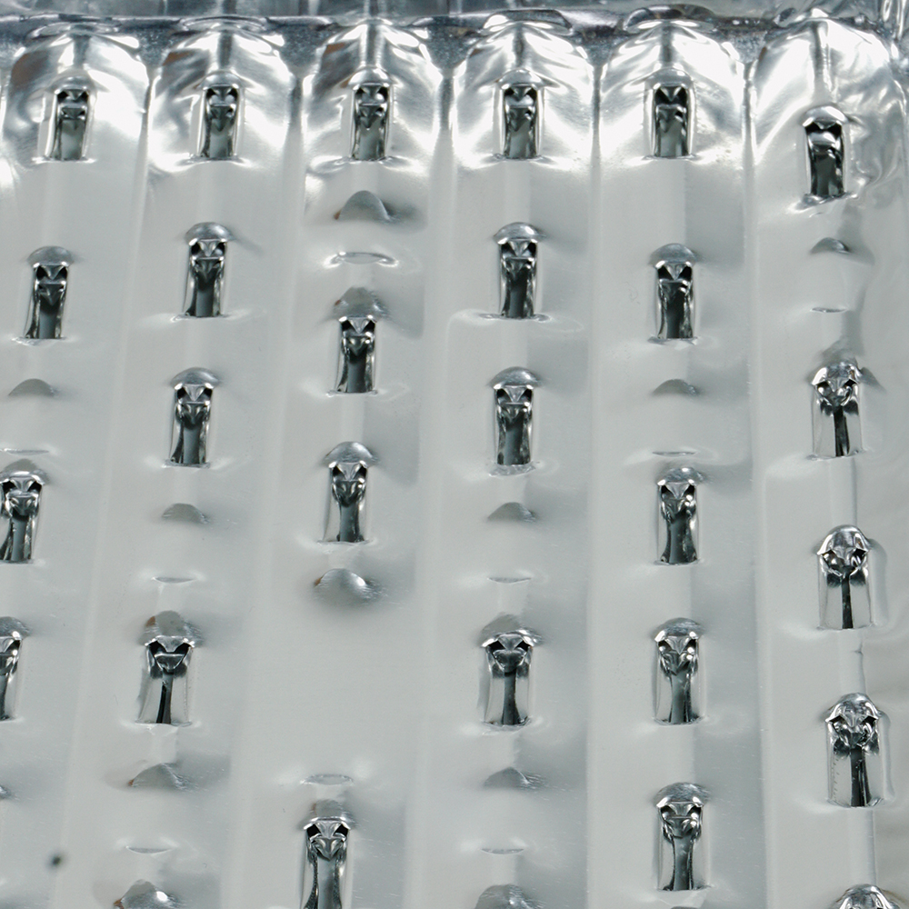 Close up of a metal grater with many small, sharp holes.