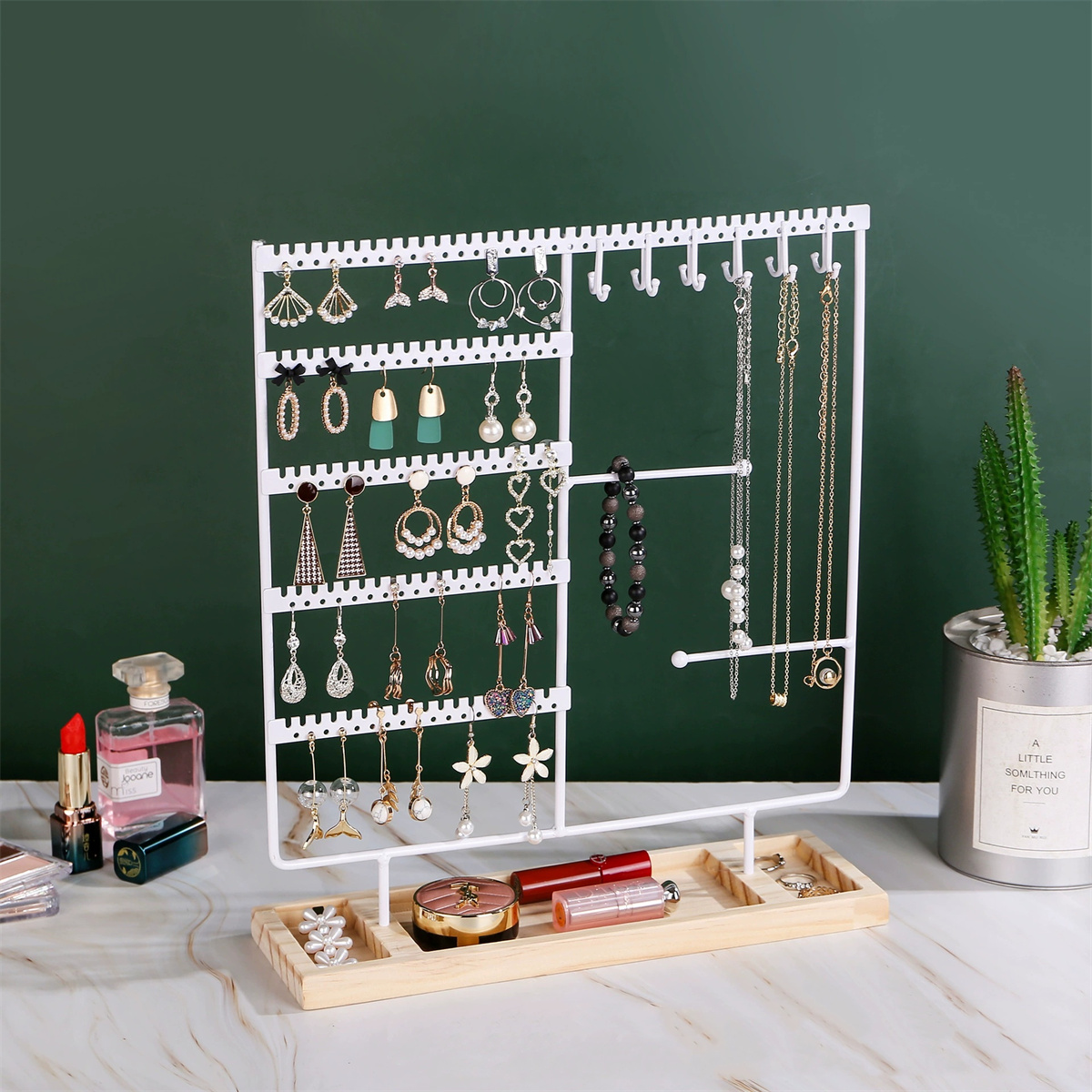 Eine weiße Schmuckauslage mit Ohrringen, Halsketten und einem Tablett mit Ringen und Lippenstiften.