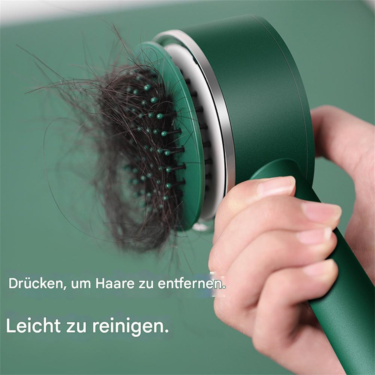 Haarbürste entfernt Haare. Dunkelgrün, mit weißem, silbernem Kopf.