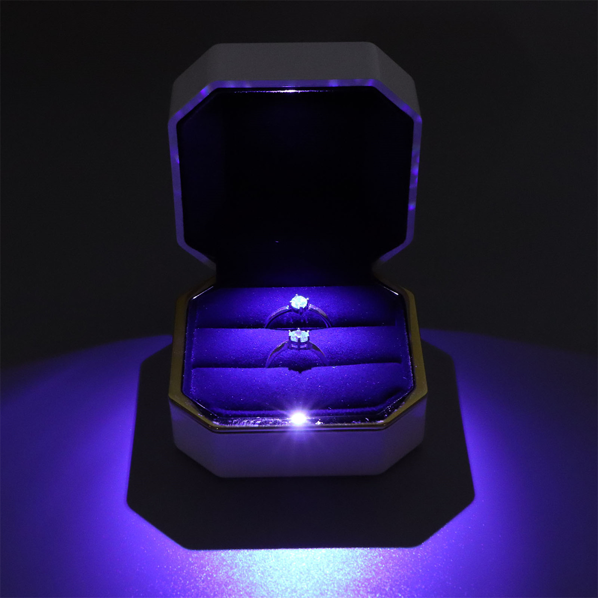 Eine beleuchtete Schmuckschatulle mit zwei Ringen.