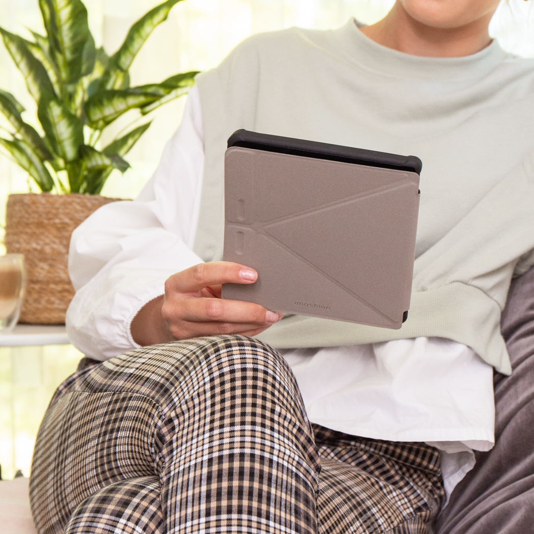 Vrouw houdt tablet in hoes vast, zittend op een bank.