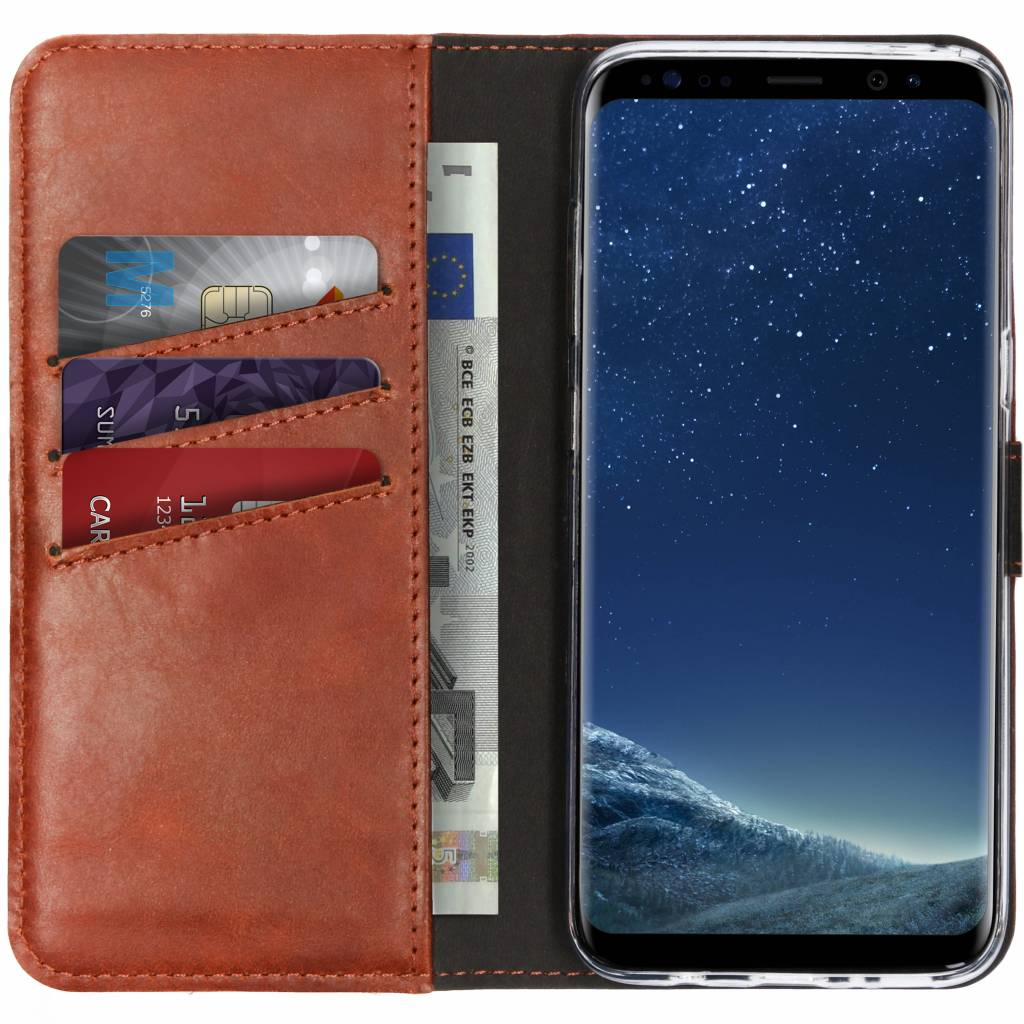 Étui de téléphone en cuir marron avec cartes, argent et téléphone.