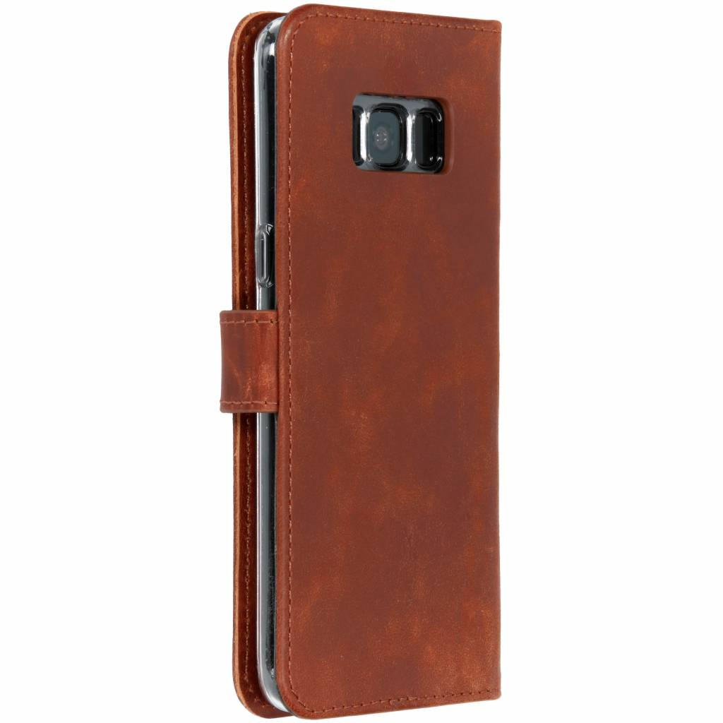 Un étui de téléphone en cuir marron, fermé, avec une fermeture magnétique.