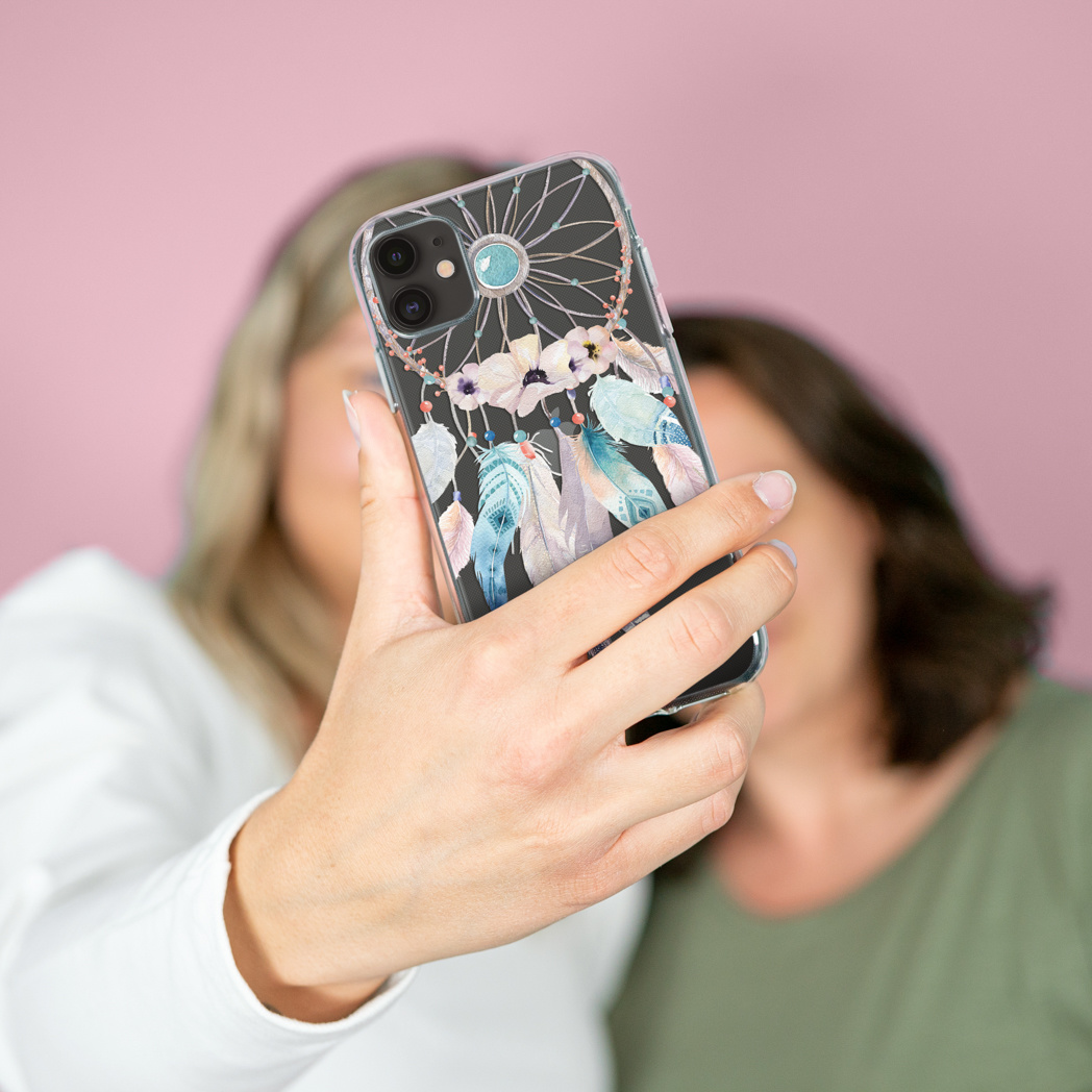 Deux femmes tenant un téléphone avec un étui. L'étui présente un motif attrape-rêves.