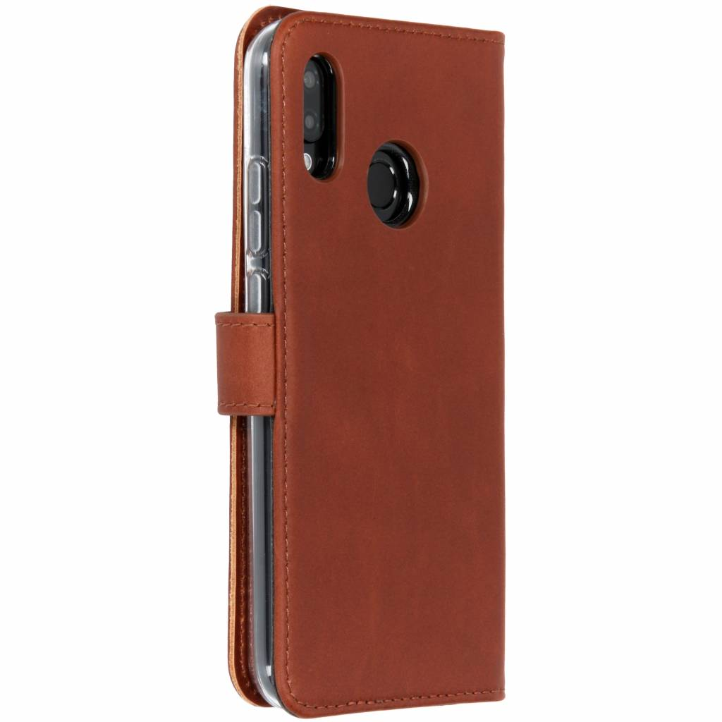 Brown leather phone case. The phone is inside. The case has a magnetic flap closure. Case has a black border.