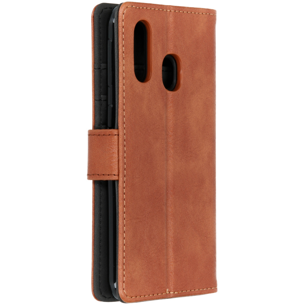 Gesloten bruine leren telefoonhoes. Het heeft een magnetische sluiting en een zwarte binnenste telefoonhouder.