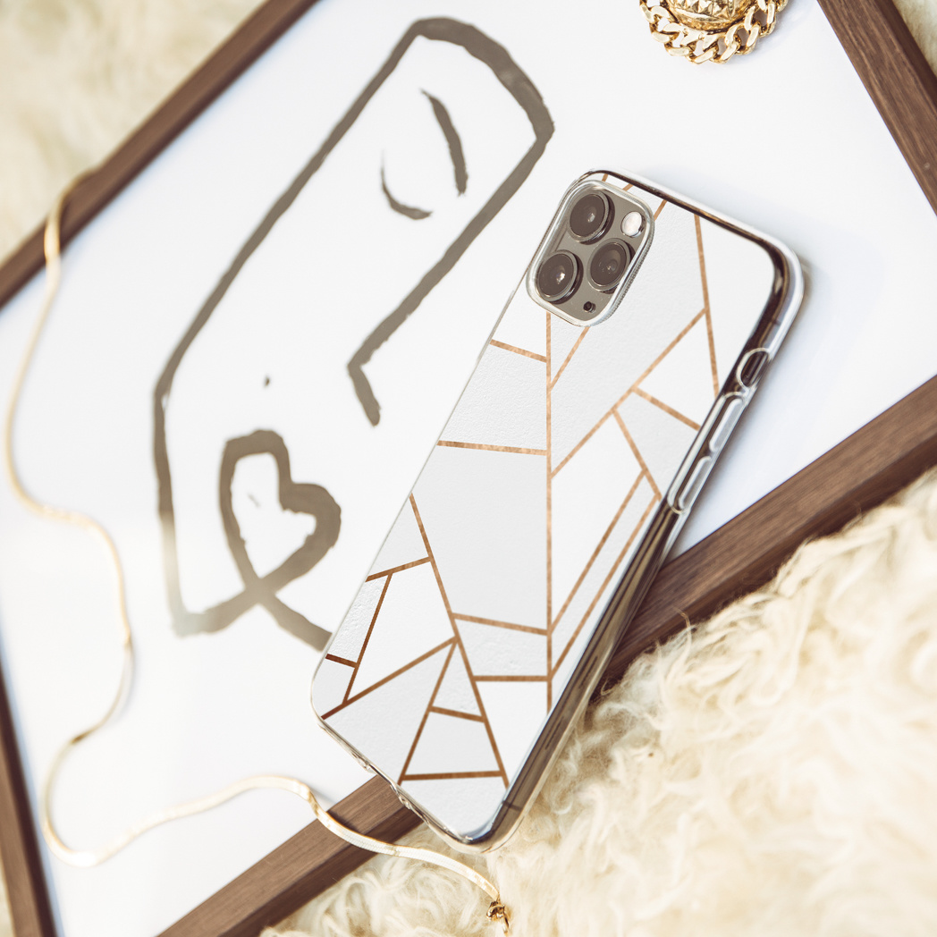 Coque de téléphone sur un dessin. Une chaîne en or et une bague en or.