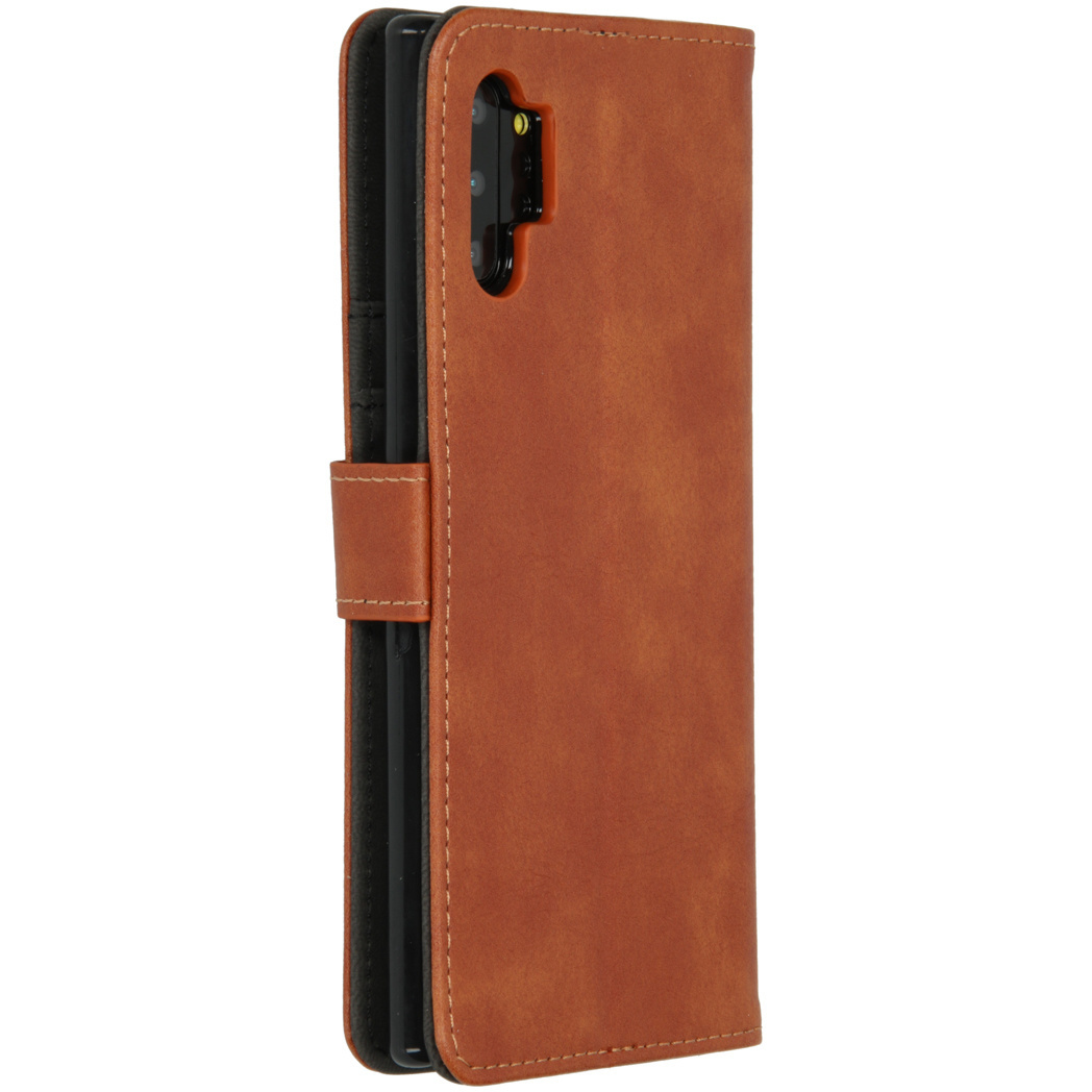 Étui de téléphone en cuir marron ouvert. Le téléphone est à l'intérieur. Fond blanc.