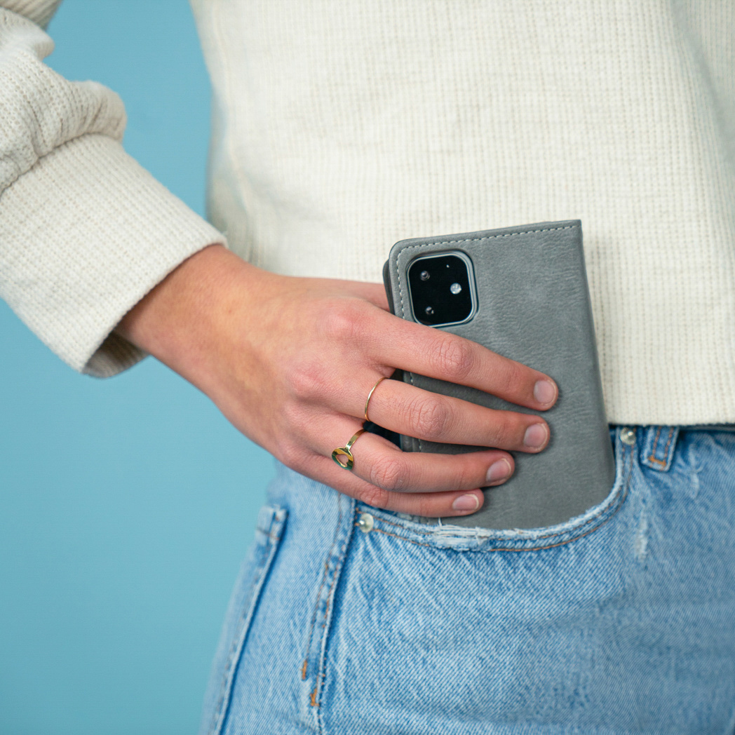 Hand van een persoon in een zak met een telefoonhoesje.