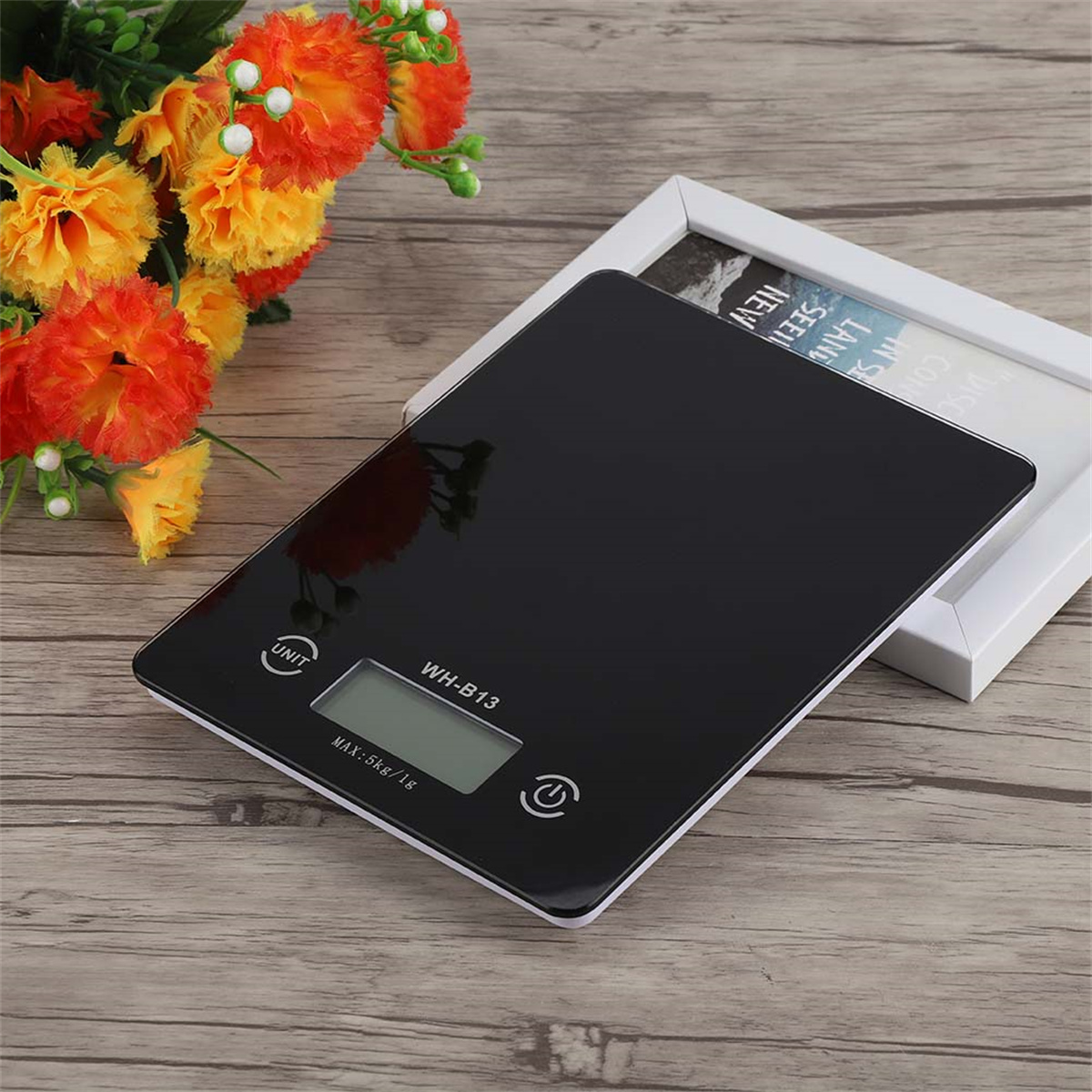 Eine schwarze digitale Küchenwaage mit weißem Rahmen und Display.