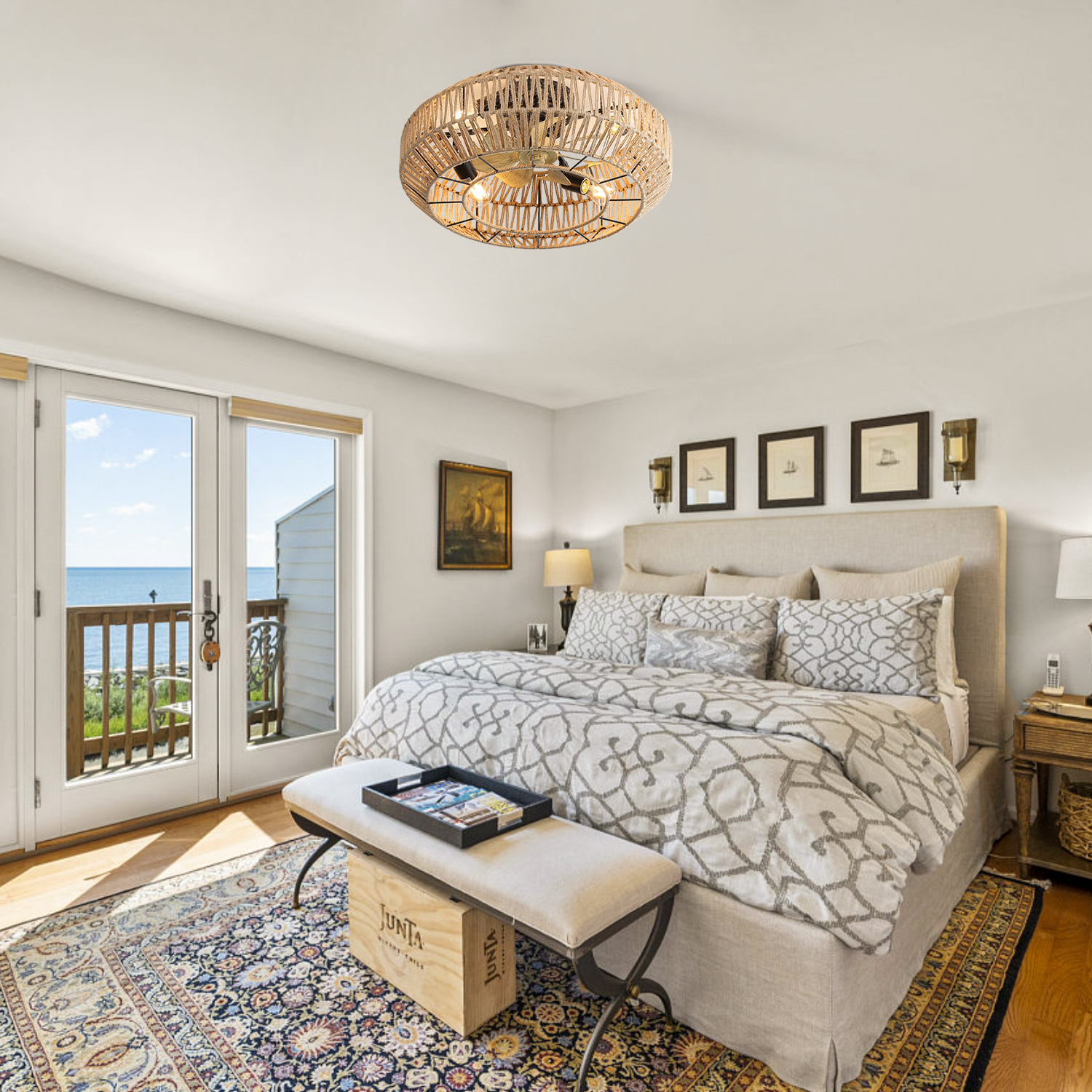 Schlafzimmer mit Bett, Teppich, Bank und Blick auf das Meer durch Doppeltüren.