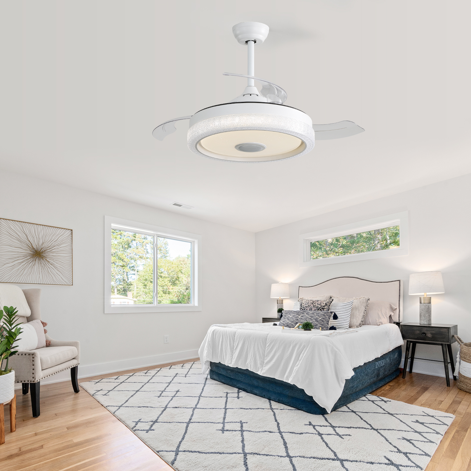 Ein weißer Deckenventilator mit Lichtern und ein Bett in einem gut beleuchteten Schlafzimmer.