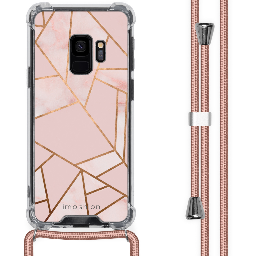 Roze telefoonhoesje met gouden design. De achtergrond heeft een roze koord.