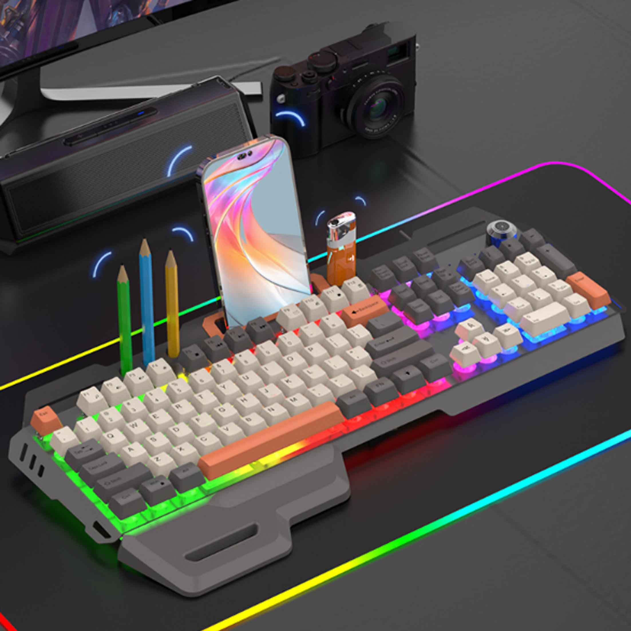 Klawiatura z telefonem, ołówkami i aparatem. Widoczne efekty oświetlenia RGB.