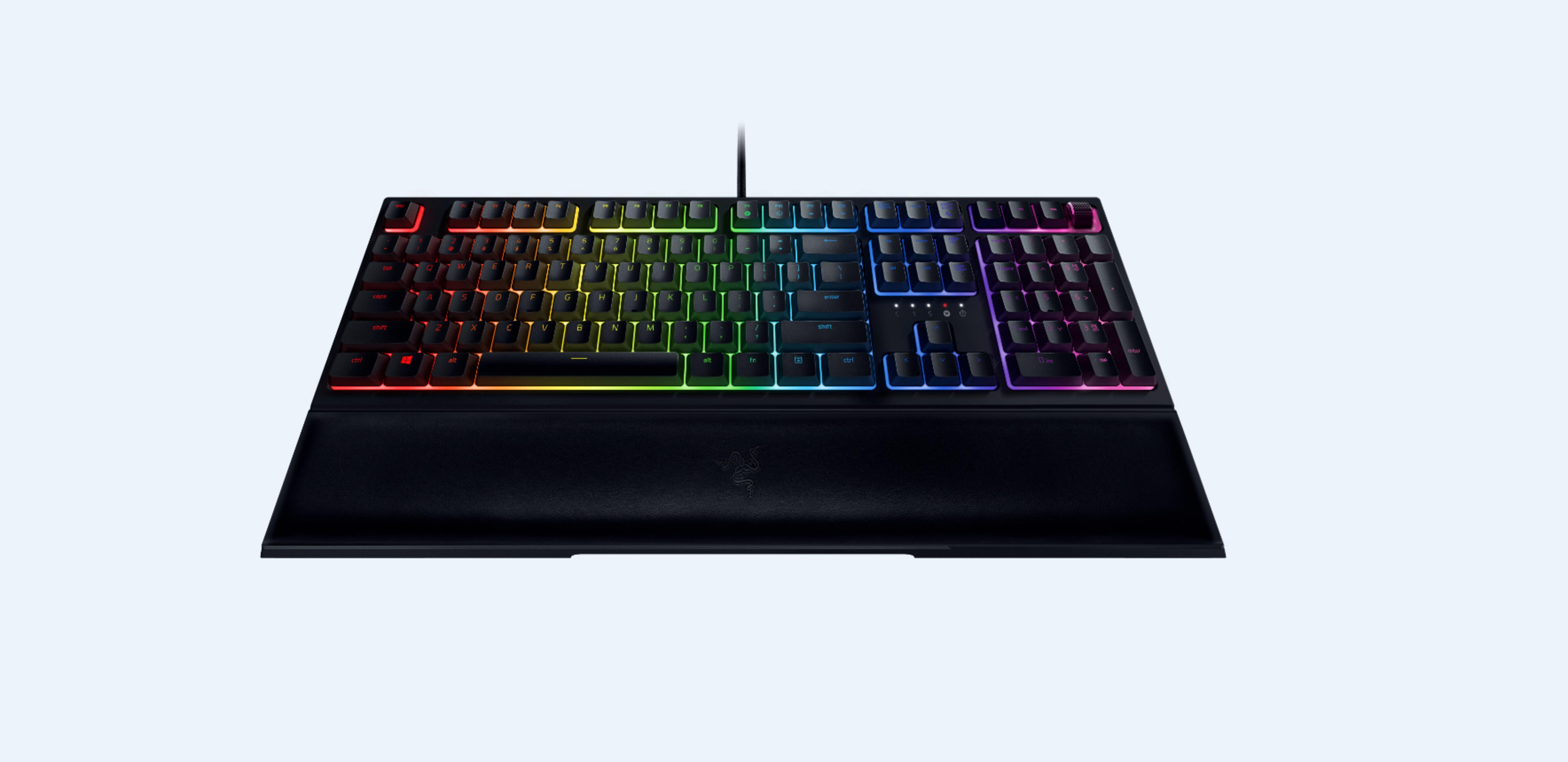 Schwarze Tastatur mit Regenbogen-Tasten. Die Tastatur hat eine Handballenauflage. Auf blauem Hintergrund.