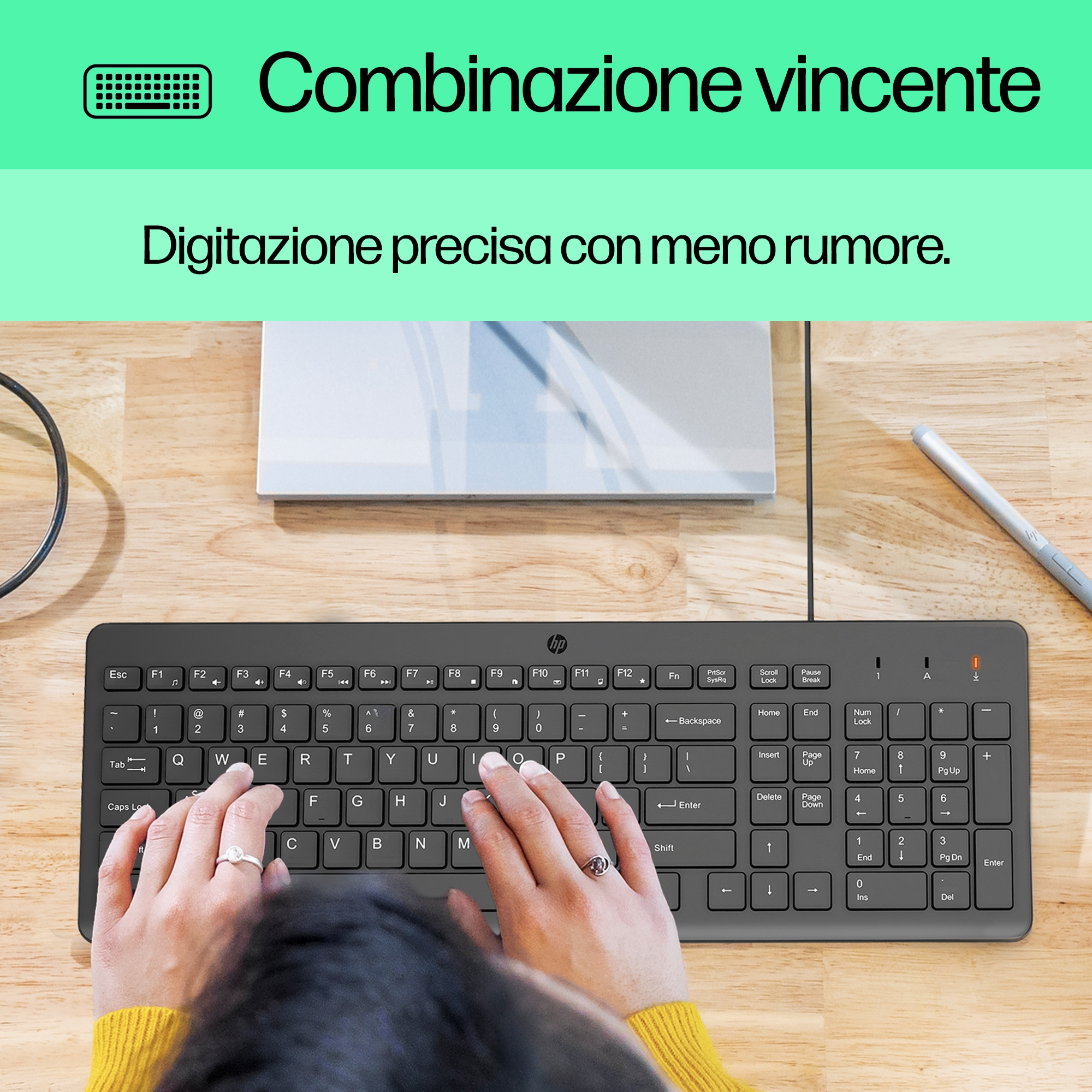 Ręce osoby piszącej na czarnej klawiaturze. Klawiatura jest podłączona do komputera.