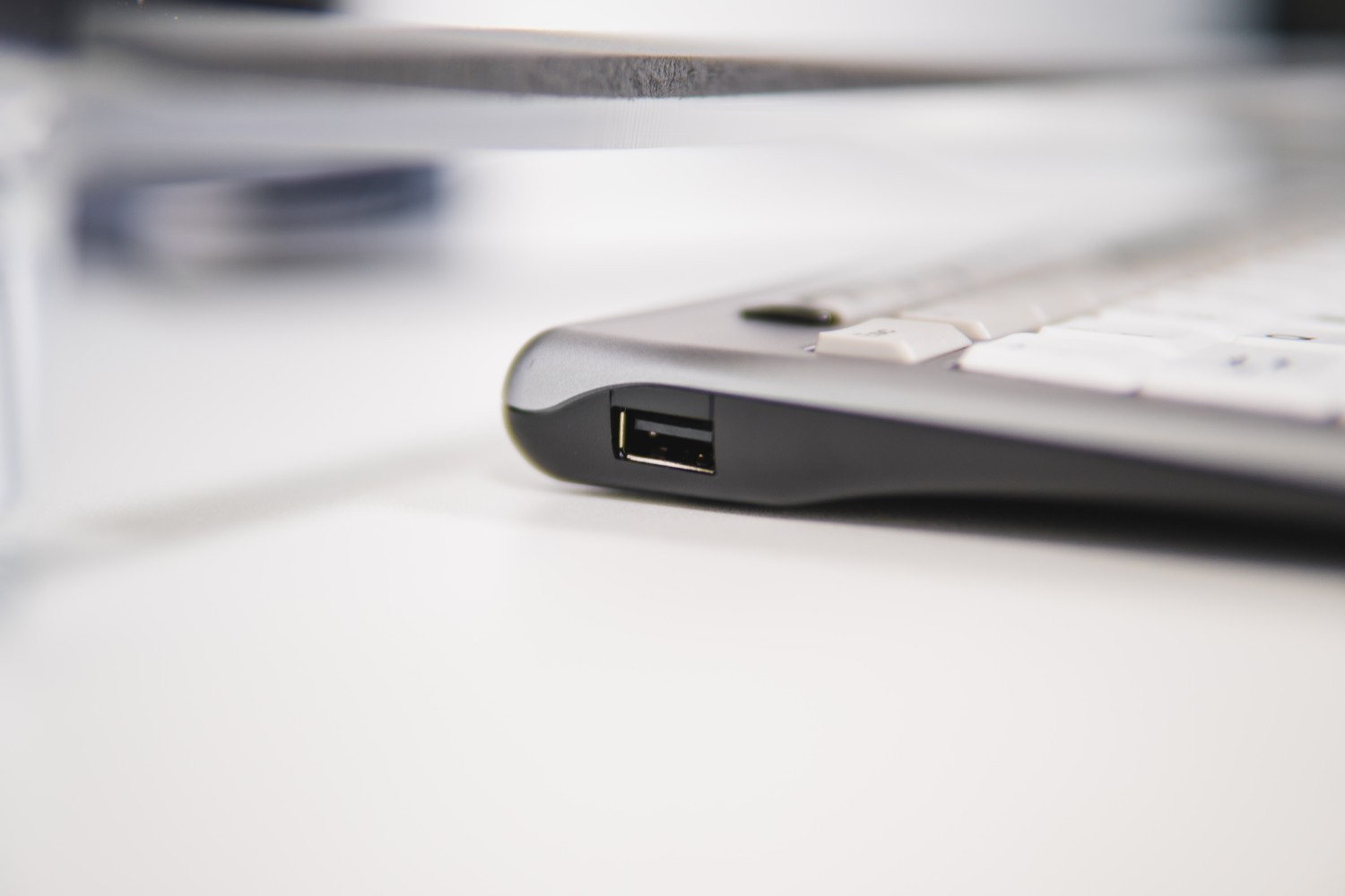 Zbliżenie portu USB na klawiaturze. Klawiatura jest szara i biała.