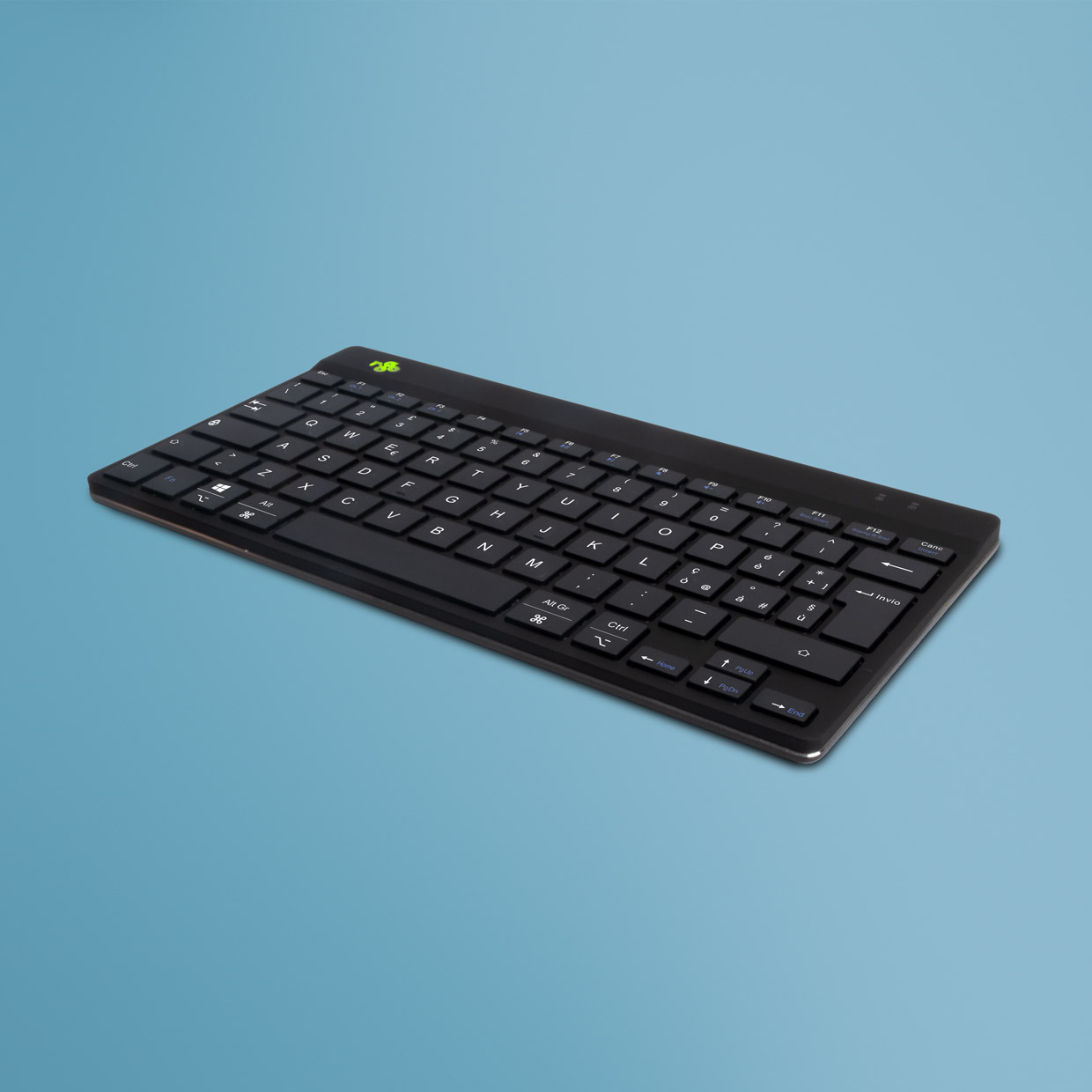 Eine schwarze, kompakte Tastatur auf einer blauen Oberfläche. Die Tastatur hat grüne Akzente.
