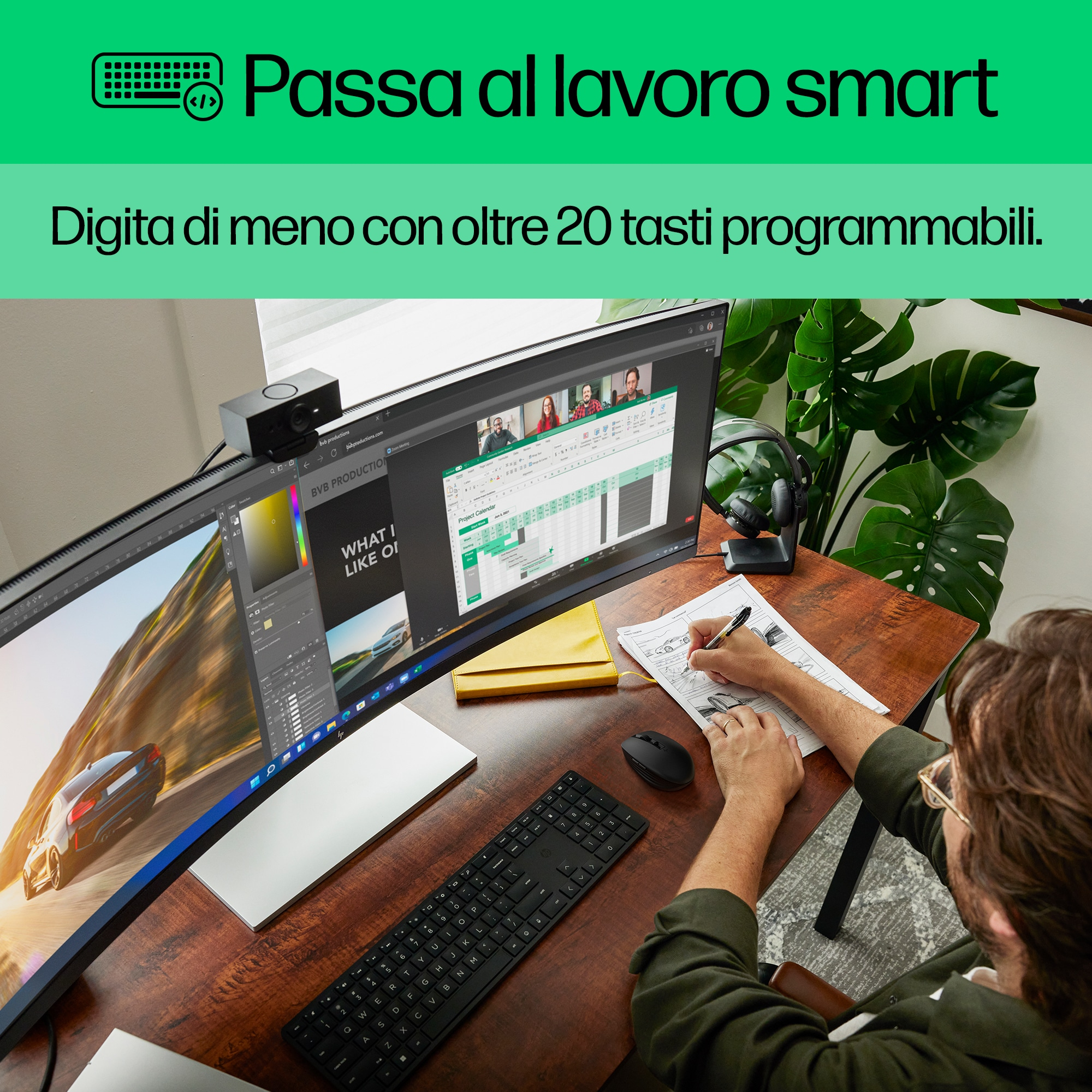 Mężczyzna pracuje na komputerze z dużym zakrzywionym ekranem, pisze na kartce papieru.